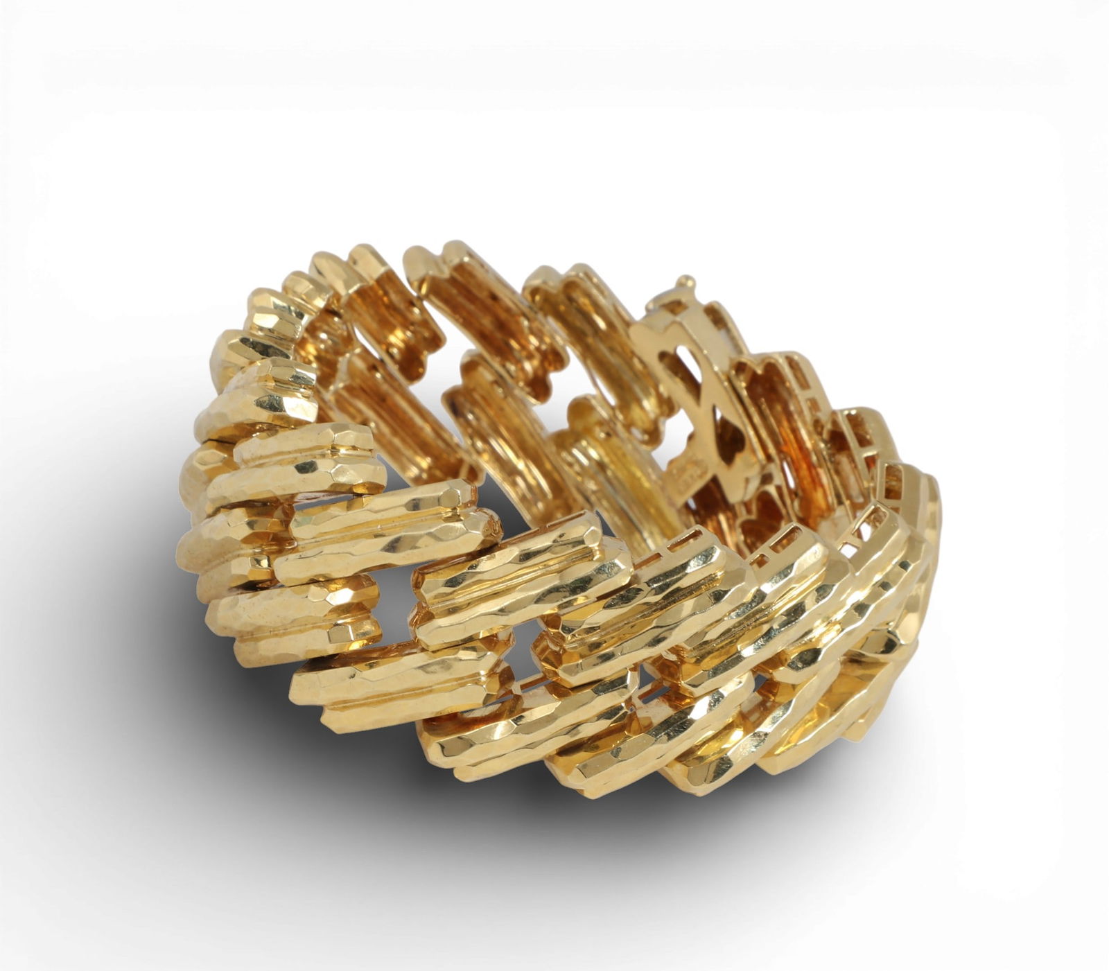 Henry Dunay: An 18K yellow gold bracelet,measures approximately 7.75 x 1.1in (19.5 x 2.75cm); gross: Henry Dunay: An 18K yellow gold braceletOpenwork design with hammered finish diagonal links with fold over interlocking clasp. Together with one volume; Henry Dunay A Precious Life.measures approximat