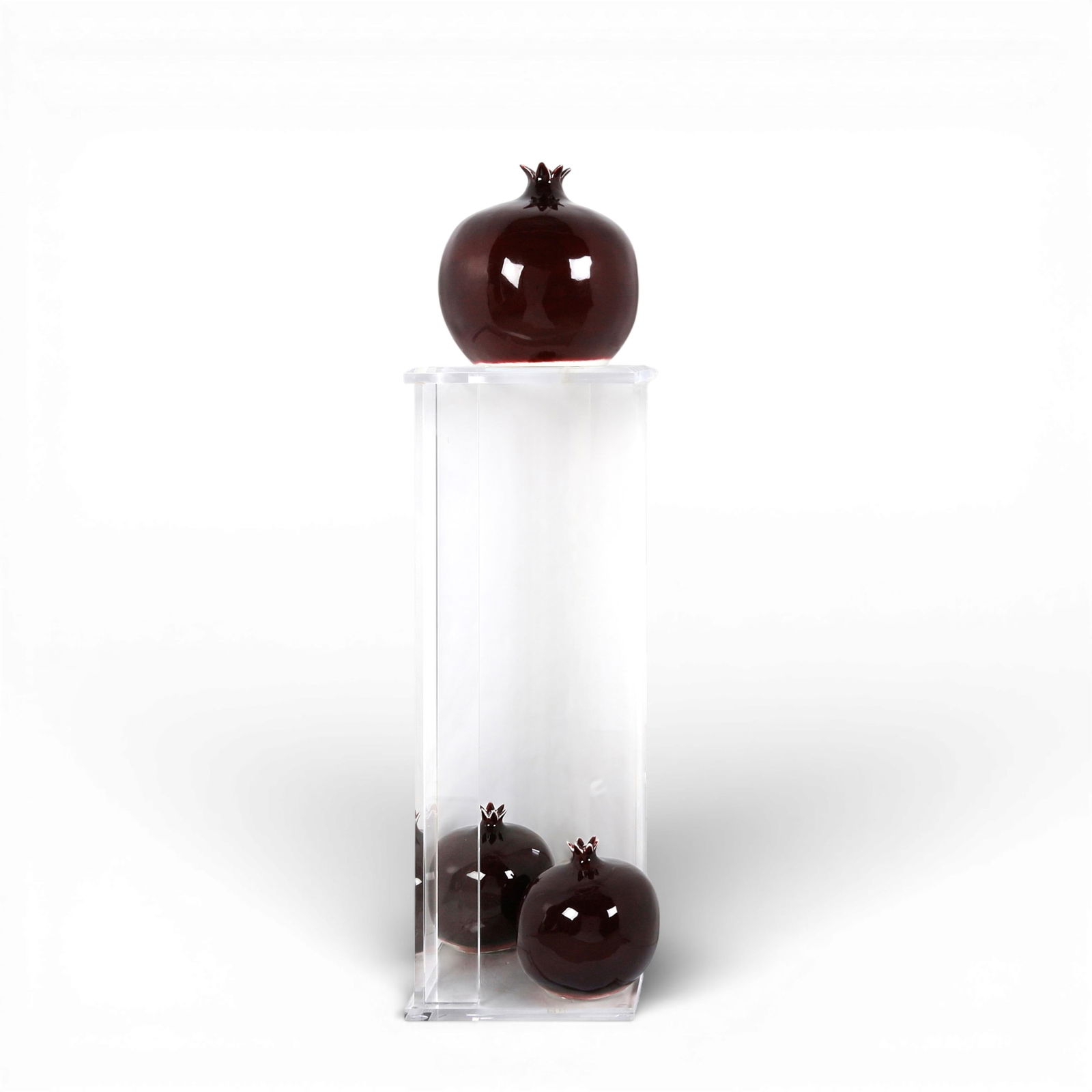 A set of three Lisa Pappon for Bull & Stein glazed ceramic models of pomegranates, modern: A set of three Lisa Pappon for Bull & Stein glazed ceramic models of pomegranatesmodernEach with impressed factory mark to underside; together with a lucite stand.largest height 14 1/4in (36cm); diame