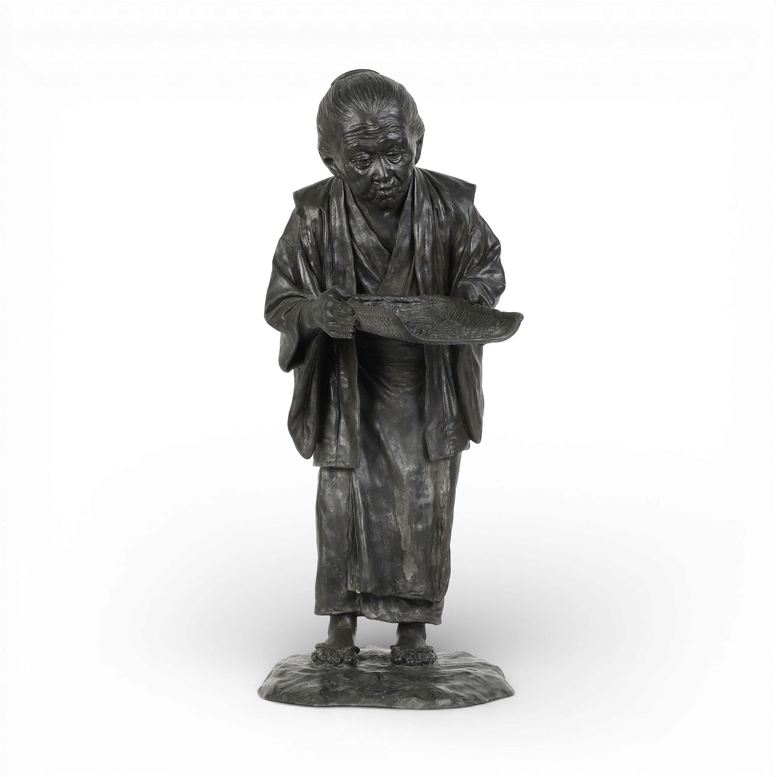 A large Japanese bronze okimono of a woman with a basket of grain: A large Japanese bronze okimono of a woman with a basket of grainIncised characters to base on reverse and to left edge.height 22 1/2in (57cm); width 10in (25.5cm); depth 14 1/2in (37cm) Provenance:P