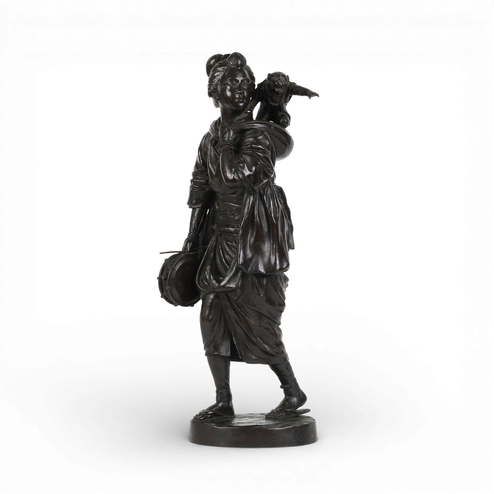 A Japanese patinated bronze okimono of a woman with a monkey on her back: A Japanese patinated bronze okimono of a woman with a monkey on her backIncised mark to base.height 18 1/2in (47cm); width 8in (20cm); depth 6 1/2in (16.5cm) Provenance:Property from a Private Collec