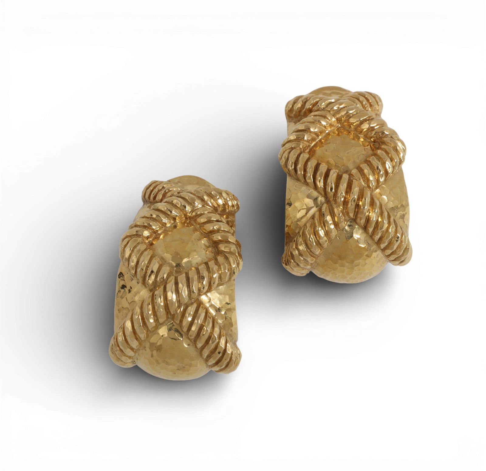 David Webb: A pair of 18K yellow gold earrings,approximate length 1.5in (3.75cm) long; width .5 to: David Webb: A pair of 18K yellow gold earringsHammered finish clip on earrings with fluted geometric pattern tops.approximate length 1.5in (3.75cm) long; width .5 to 1in (16mm to 23mm); gross weight a