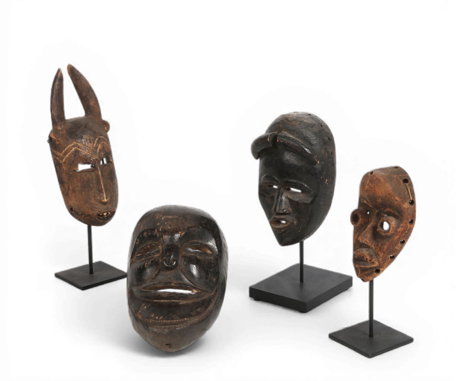 A group of four carved wood African masks (1 of 3)
