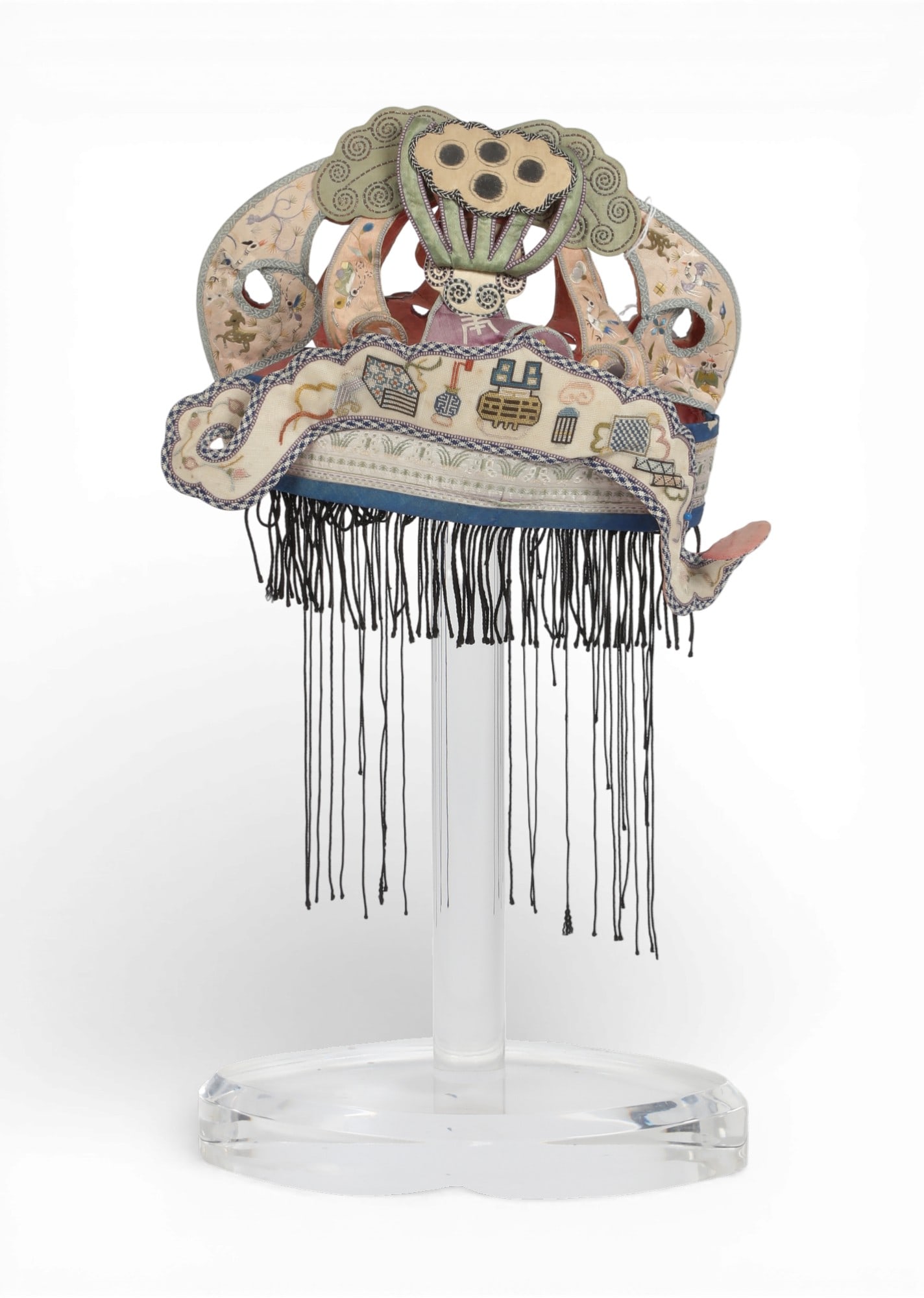 A Chinese embroidered silk festival hat: A Chinese embroidered silk festival hatOn lucite stand.hat 7 1/2in (19cm); width 11in (28cm); depth 4 1/4in (11cm)