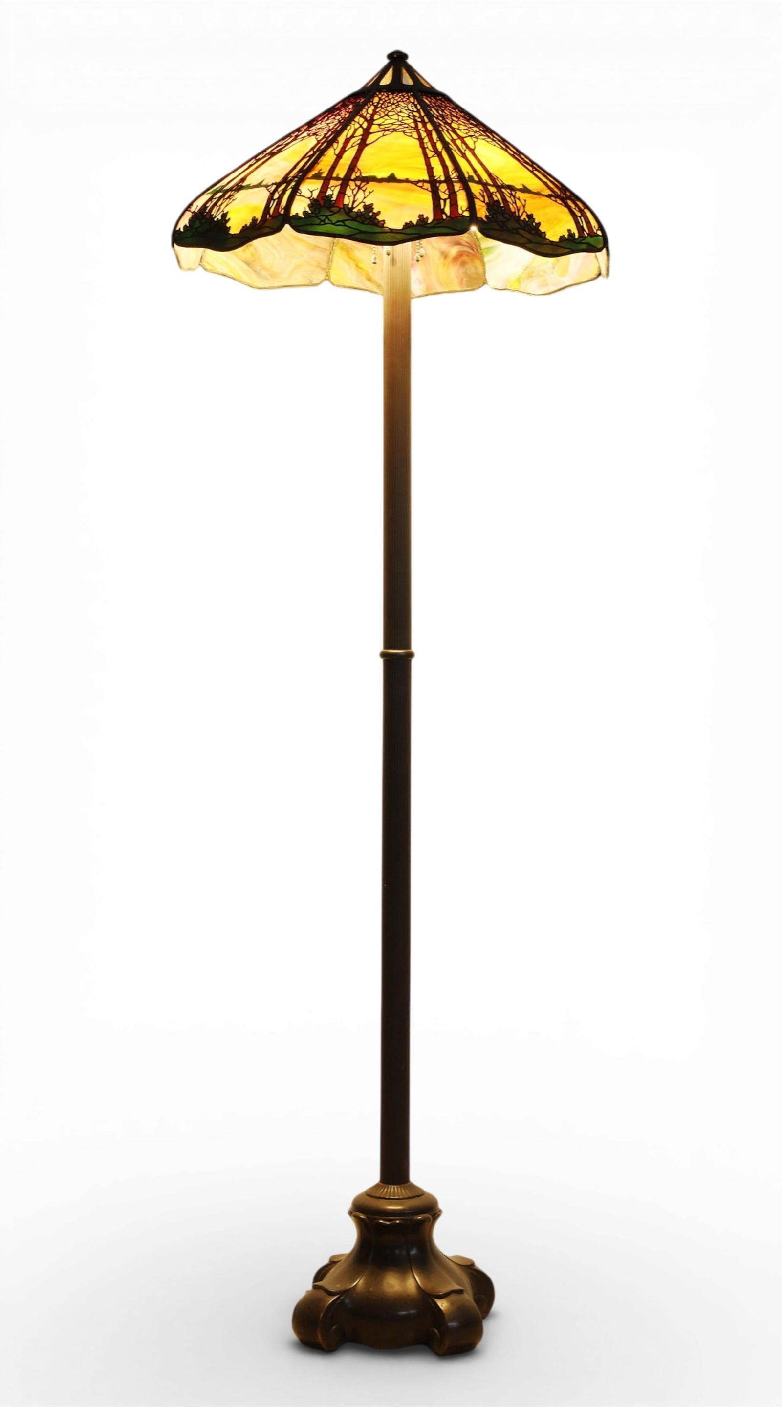 A Handel leaded slag glass Teroca sunset trees lamp shade on later associated patinated metal base: A Handel leaded slag glass Teroca sunset trees lamp shade on later associated patinated metal baseshade early 20th century, base laterShade with applied plaque, HANDEL.height 66in (165cm); diameter 23