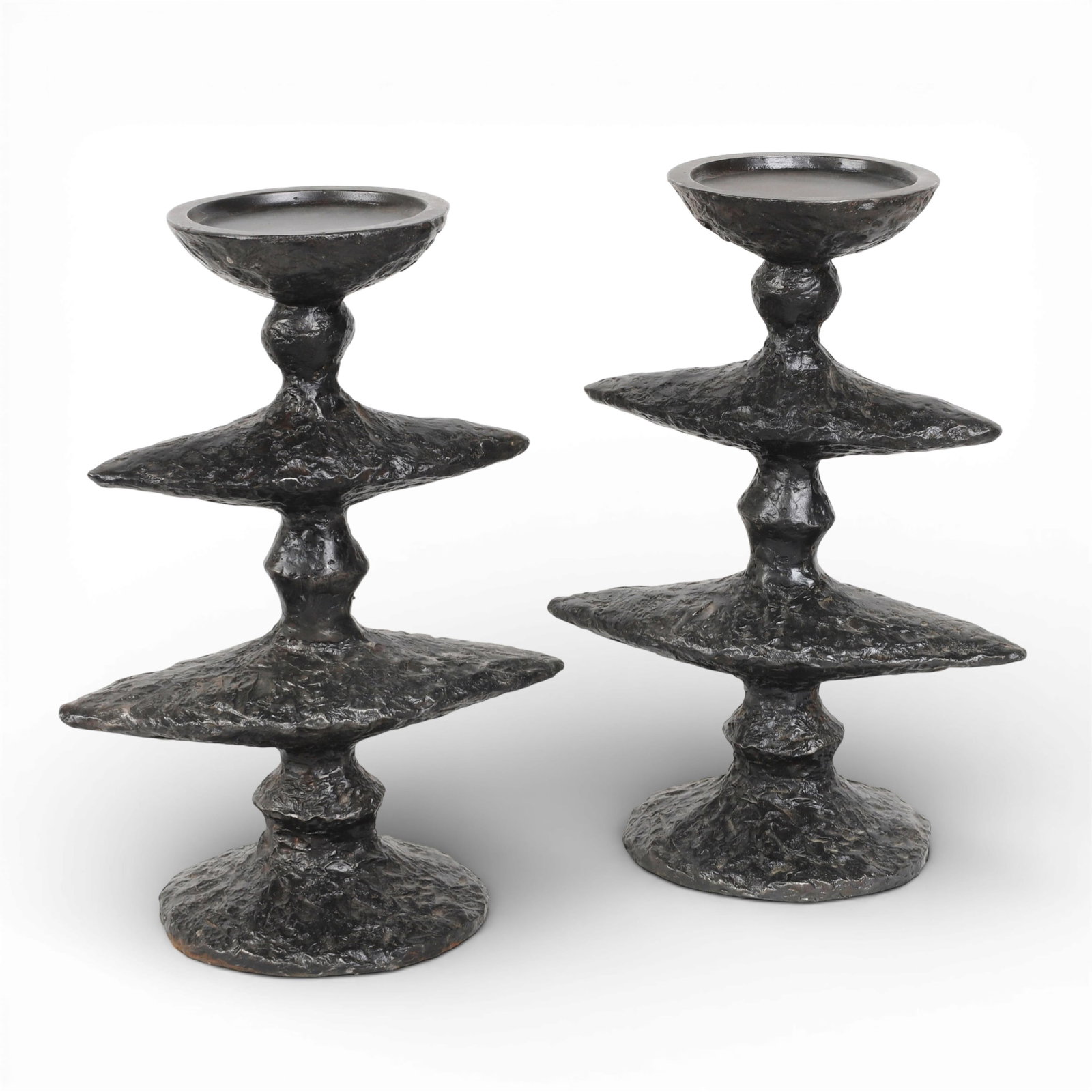 A pair of Brutalist patinated metal candle stands, modern: A pair of Brutalist patinated metal candle standsmodernheight 13 1/2in (34cm); width 10in (25.5cm); depth 6in (15cm)