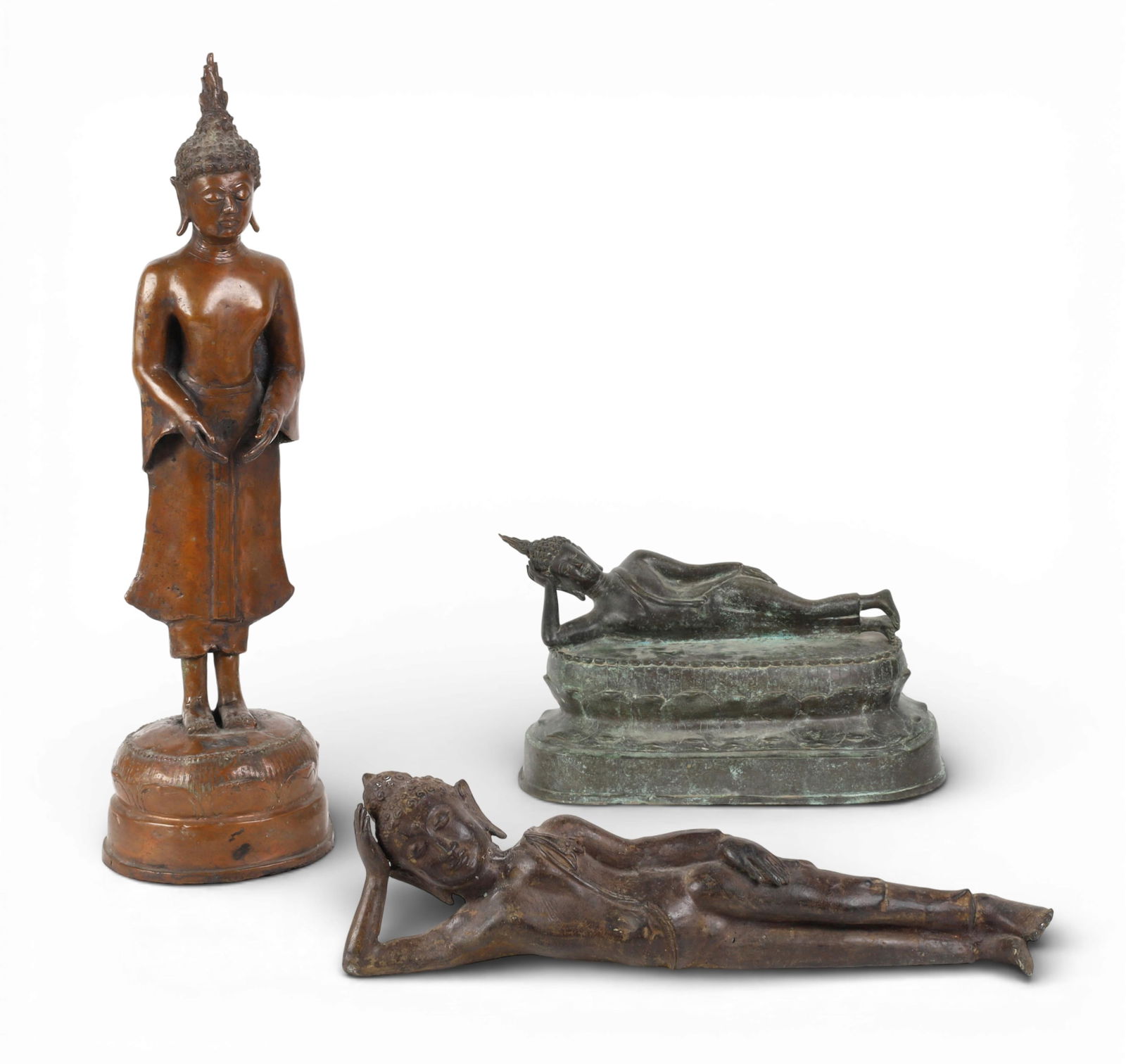 Three Southeast Asian models of Parinirvana Buddha and standing Buddha: Three Southeast Asian models of Parinirvana Buddha and standing Buddha tallest height 25in (63.5cm); greatest length 19 1/2in (50cm) Provenance: Property from the Preiser Collection.