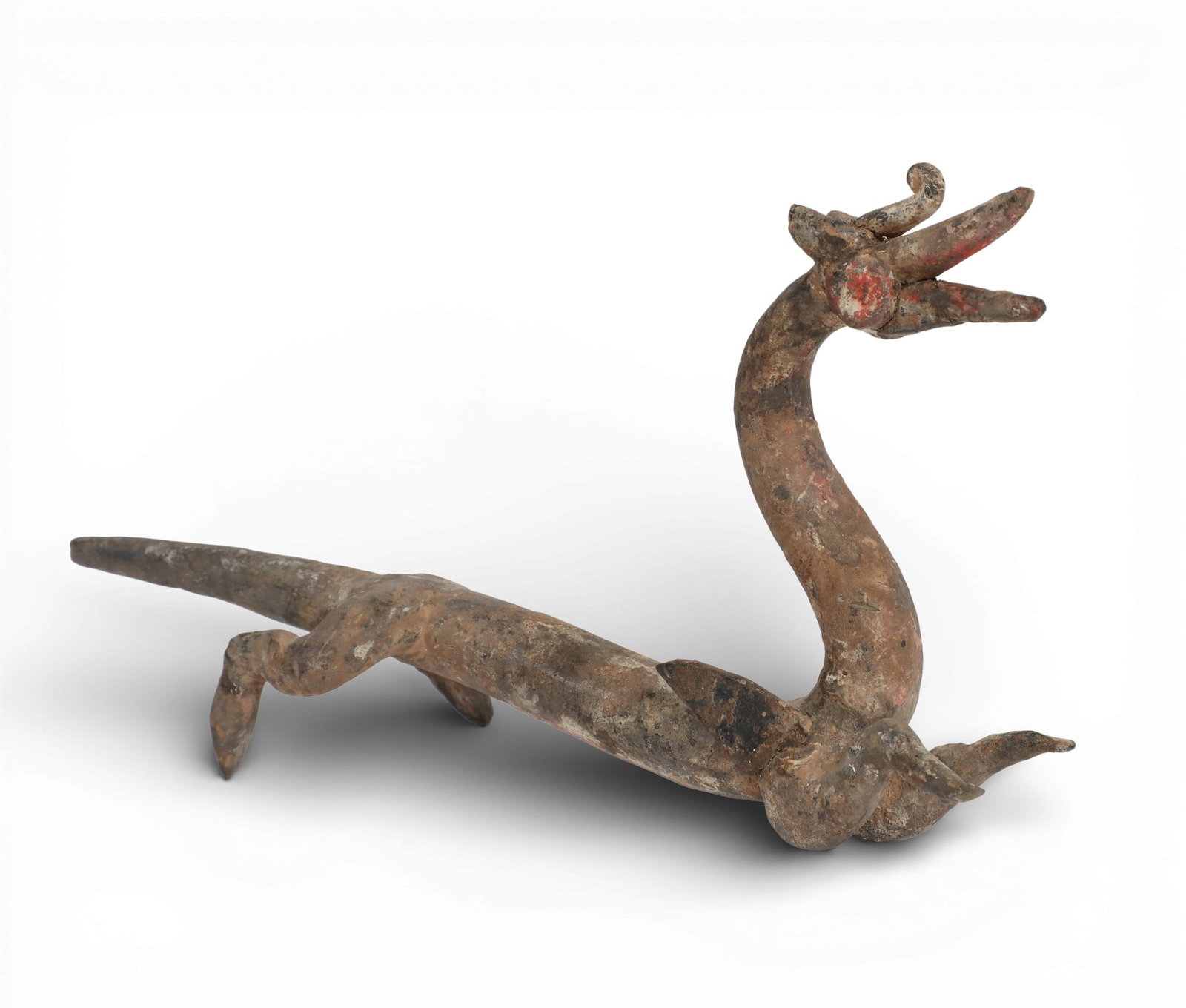 A Chinese painted grey pottery model of a dragon: A Chinese painted grey pottery model of a dragon height 5in (12.5cm); length 8 1/2in (21.5cm); width 2in (5cm) Provenance: Property from the Preiser Collection.