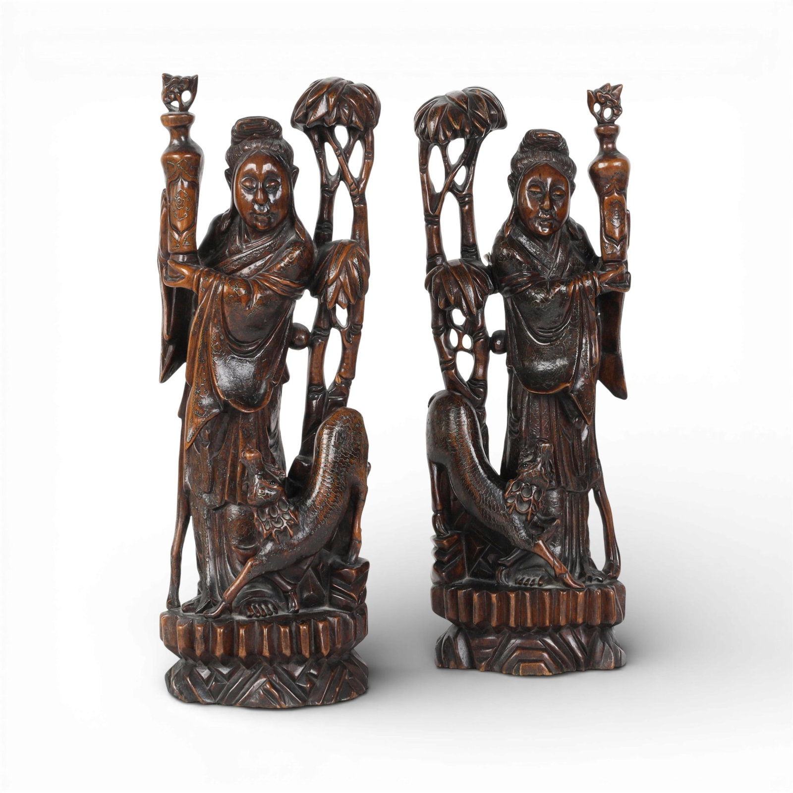 A pair of Chinese inlaid stained teak models of Guanyin: A pair of Chinese inlaid stained teak models of Guanyin height 18 3/4in (48cm); width 6 1/2in (17cm); depth 4in (10cm)