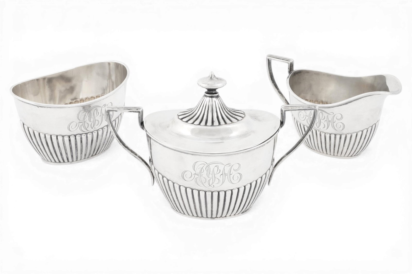A three piece sterling silver table articles including sugar, creamer, and a covered bowl, approx. (1 of 7)