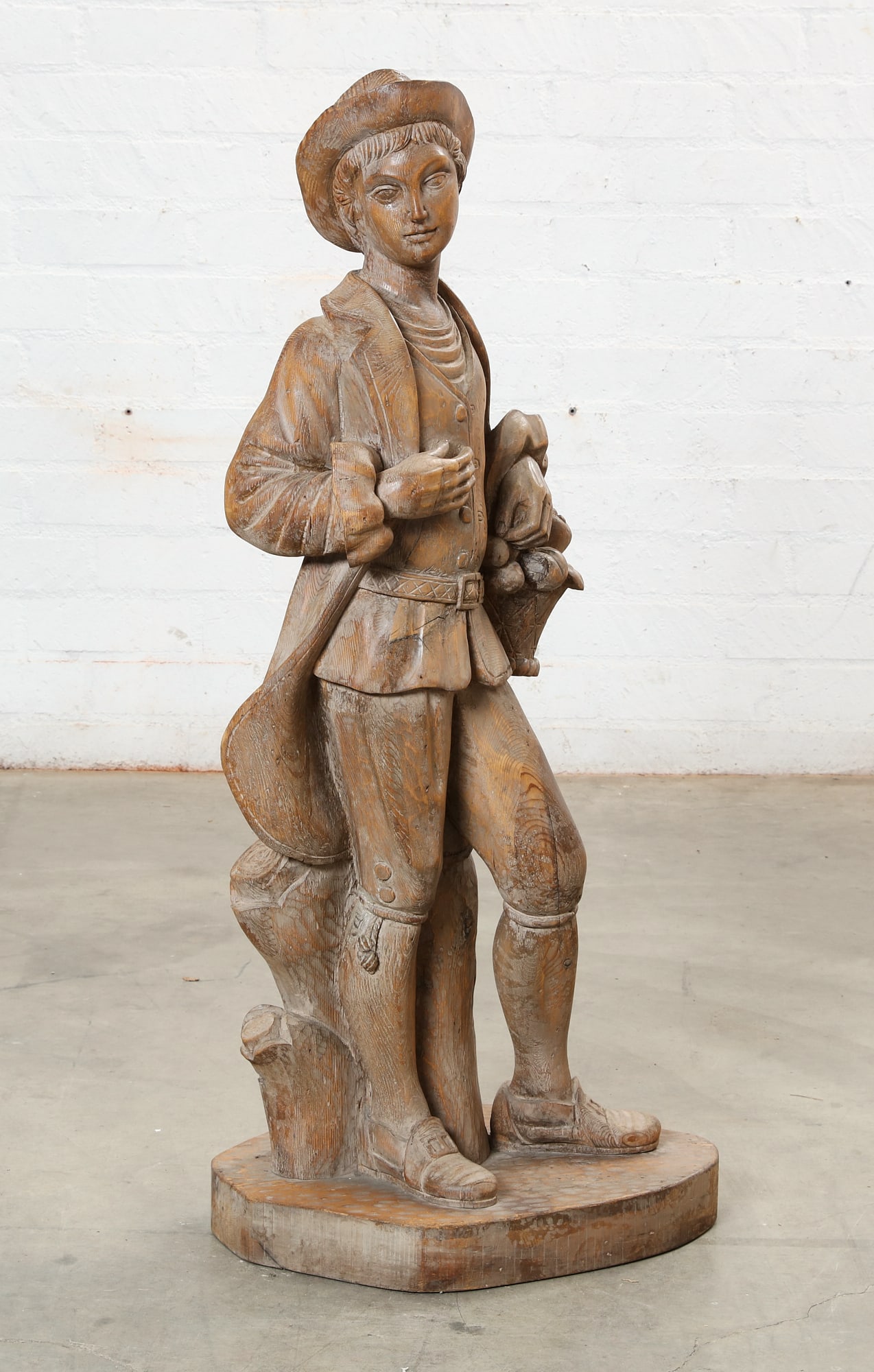 A large Continental pine model of a man with a fruit basket: A large Continental pine model of a man with a fruit basket height 47 1/4in (120cm); width 21in (53cm); depth 16in (40.5cm)