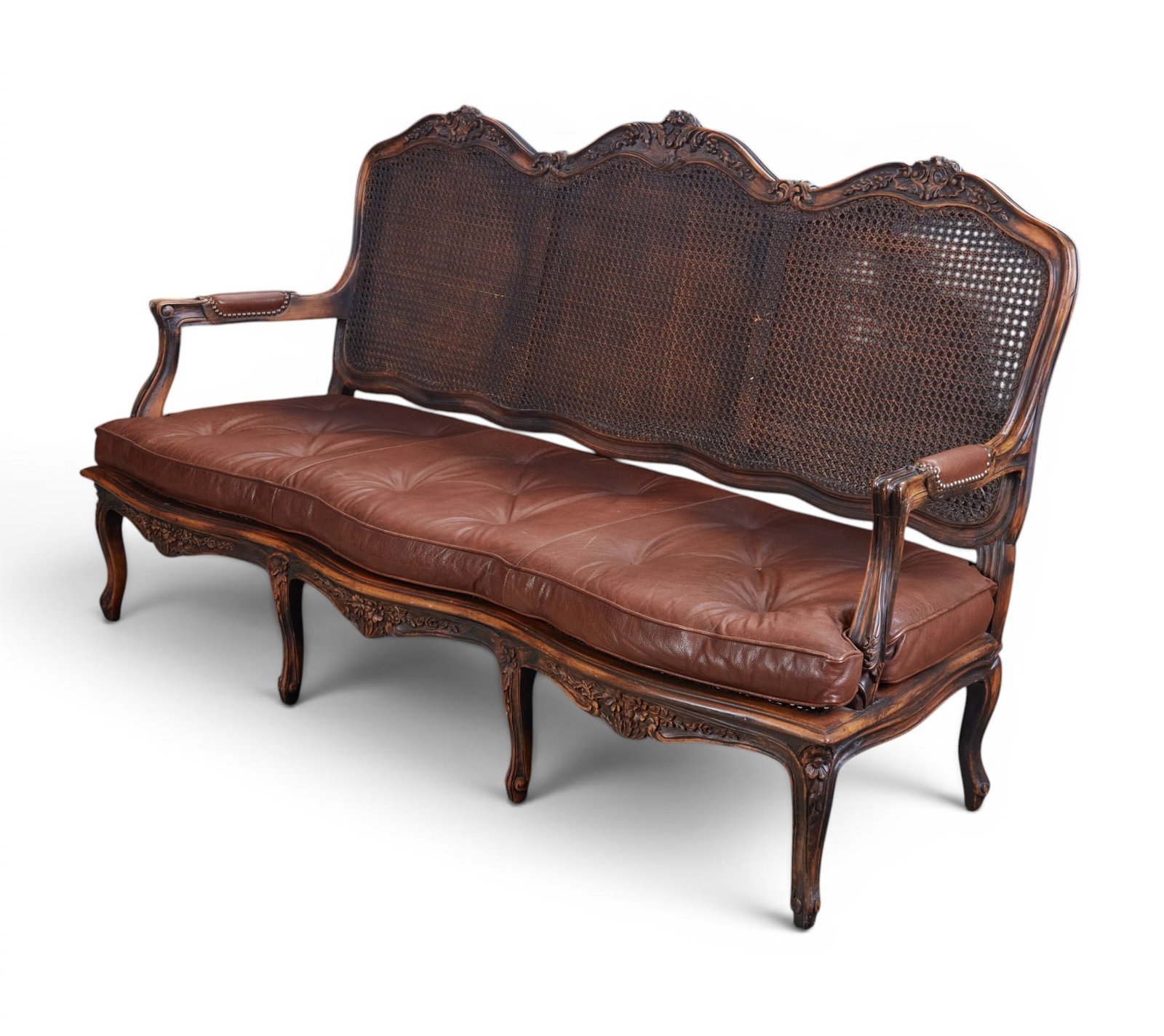 A cane back settee: A cane back settee height 43 x width 76 x depth 28 in. (109.2 x 193 x 71.1 cm.)