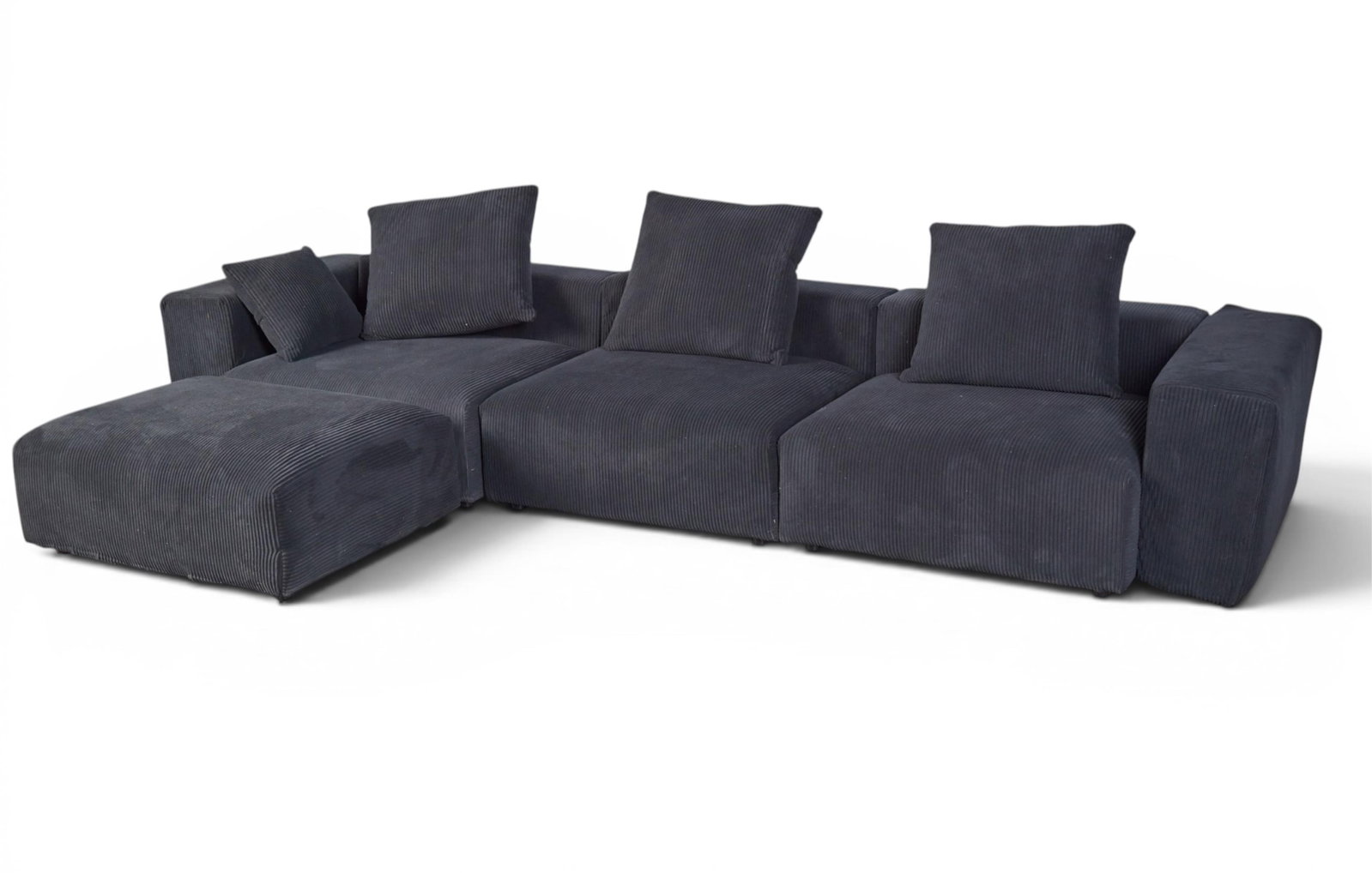 A black upholstered sofa in three parts with matching ottoman (1 of 6)