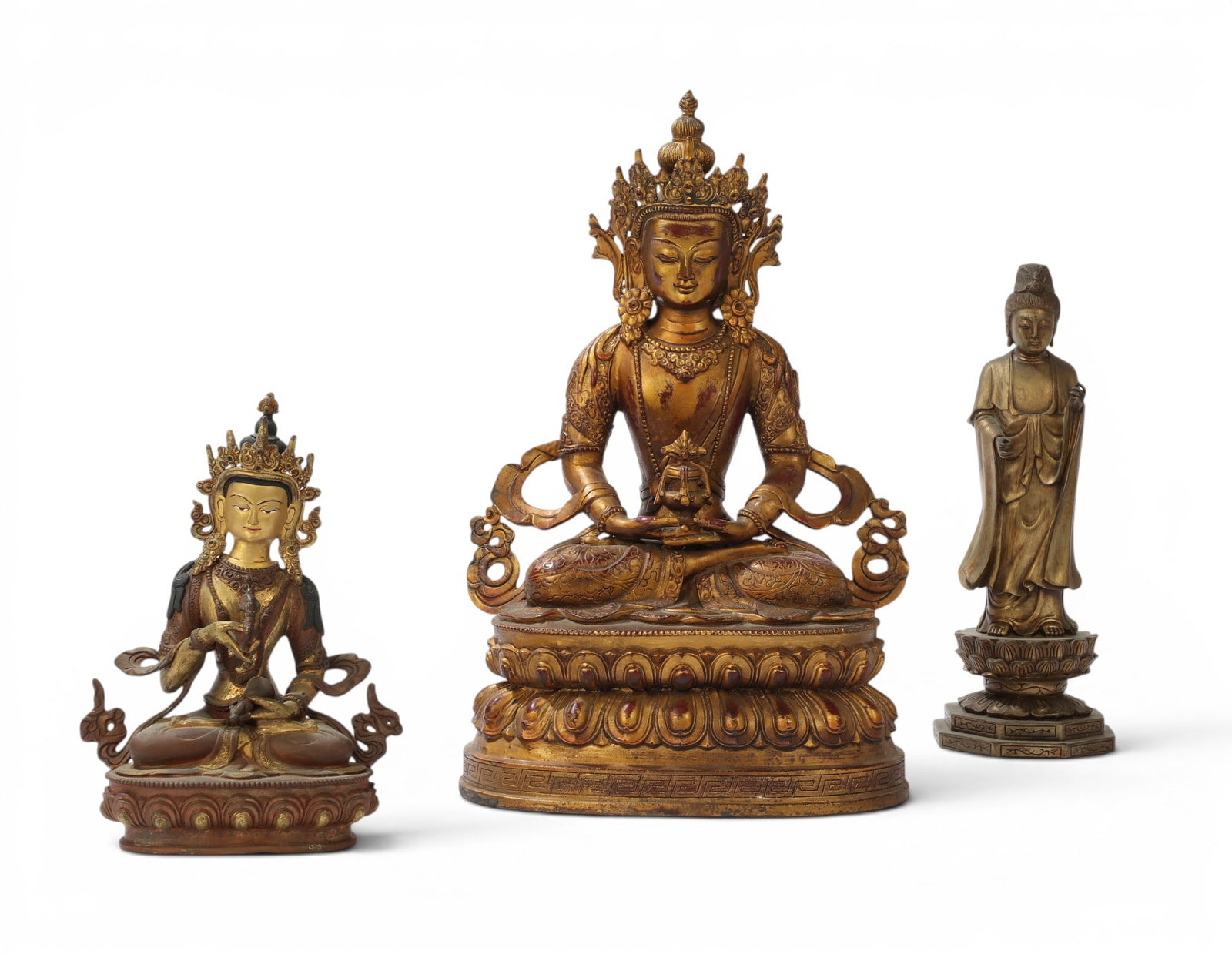 A group of three mixed metal Buddhas: A group of three mixed metal Buddhas tallest: height 14 x width 9 1/2 x depth 6 1/2 in. (35.6 x 24.1 x 16.5 cm.)
