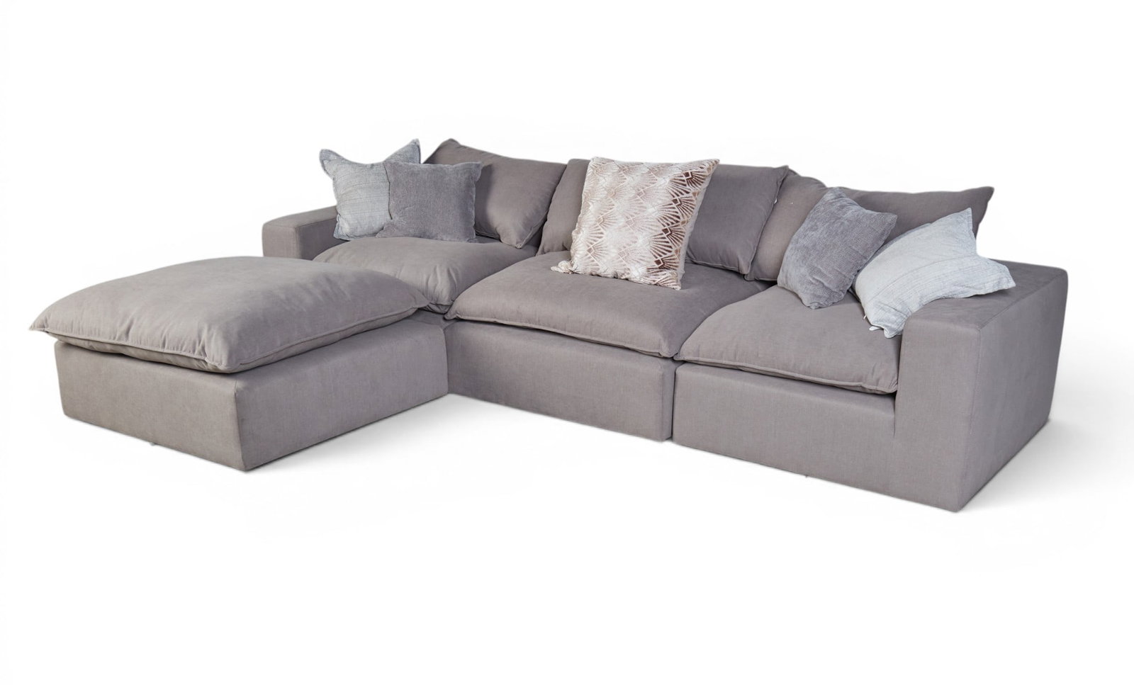 An upholstered sofa with matching ottoman and associated pillows. (1 of 6)