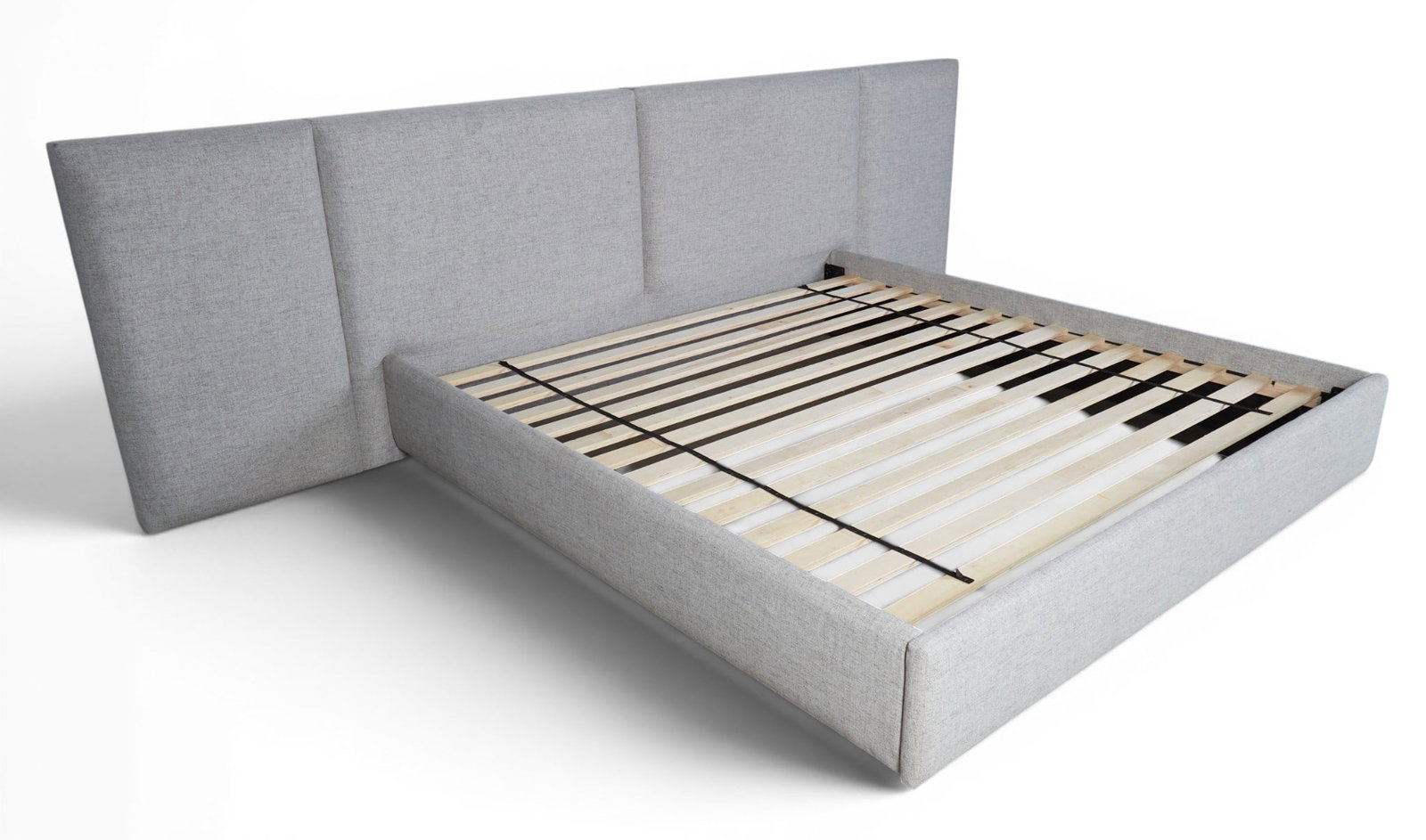 A grey upholstered king size bed: A grey upholstered king size bed height 40 x width 138 x depth 89 in. (101.6 x 350.5 x 226.1 cm.)