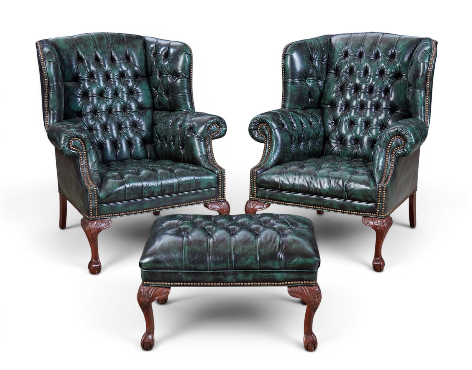 A pair of Old Hickory Tannery leather wing armchairs and matching ottoman, modern: A pair of Old Hickory Tannery leather wing armchairs and matching ottoman modern With makers labels to undersides. (3) chairs height 41in (104cm); width 35in (89cm); depth of seat 22in (56cm) Provenan