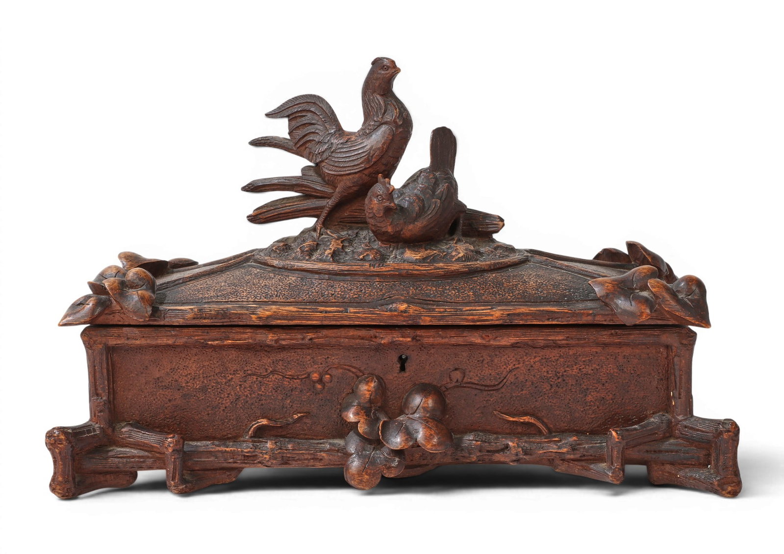A Black Forest carved linden wood glove box, late 19th century: A Black Forest carved linden wood glove box late 19th century The hinged lid centered by a rooster and a hen. height 8 1/2in (21.5cm); width 13 1/2in (34cm); depth 6 1/2in (16.5cm) Provenance: Prop