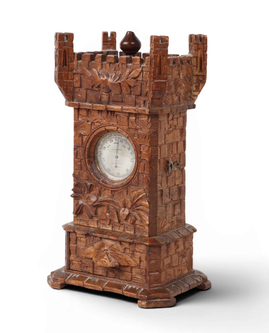 A Black Forest linden wood castle tower form watch holder, late 19th century: A Black Forest linden wood castle tower form watch holder late 19th century Enclosing a Short & Mason pocket barometer. height 9in (23cm); width 5 1/4in (13.5cm); depth 4in (10cm) Provenance: Prope
