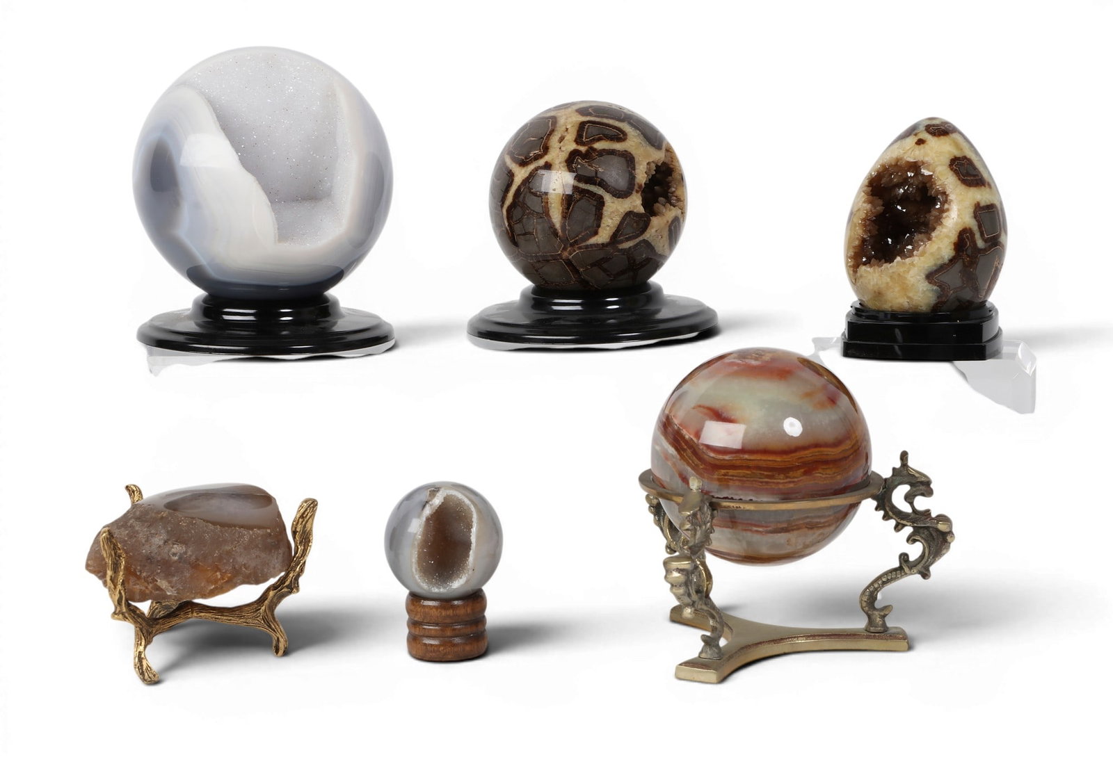 A group of six assorted polished hardstone specimans: A group of six assorted polished hardstone specimans Comprising two septarian geodes, one druzy egg form, the other a sphere; two druzy blue agate geode spheres; a banded onyx sphere; and, a rough aga