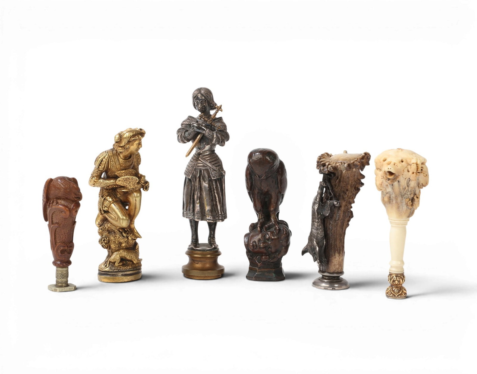 A collection of six Continental figural mixed metal, wood, and antler mounted seals: A collection of six Continental figural mixed metal, wood, and antler mounted seals 19th-20th century Comprising a patinated bronze owl, a mixed metal figure of Joan of Arc, a bronze figure of a young