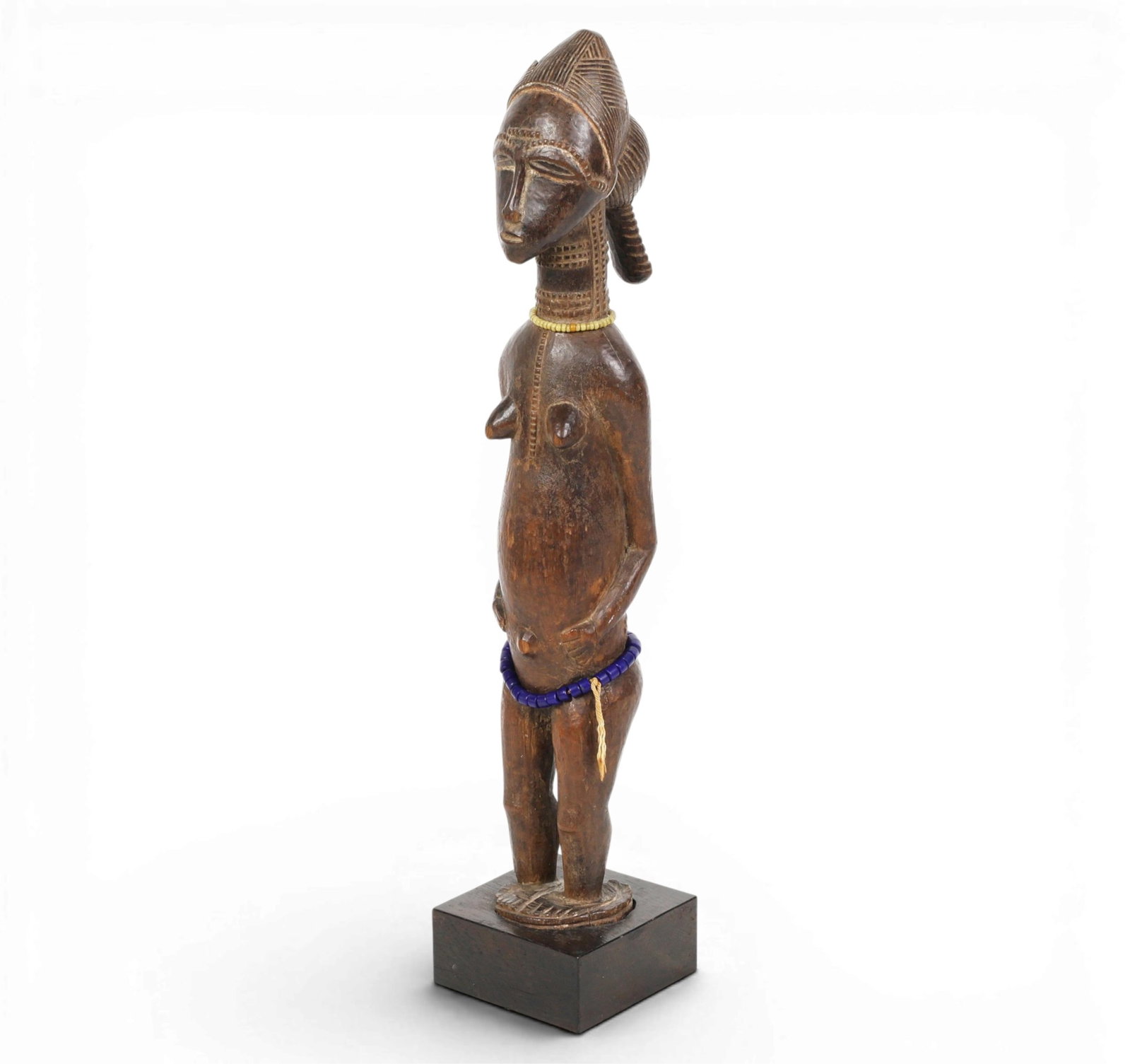 A Baule carved wood female figure: A Baule carved wood female figure overall height 16in (40.5cm); stand 3 1/4 x 3 1/4in (8 x8cm) Provenance: Property from the collection of Frederick M Nicholas, Beverly Hills, California.