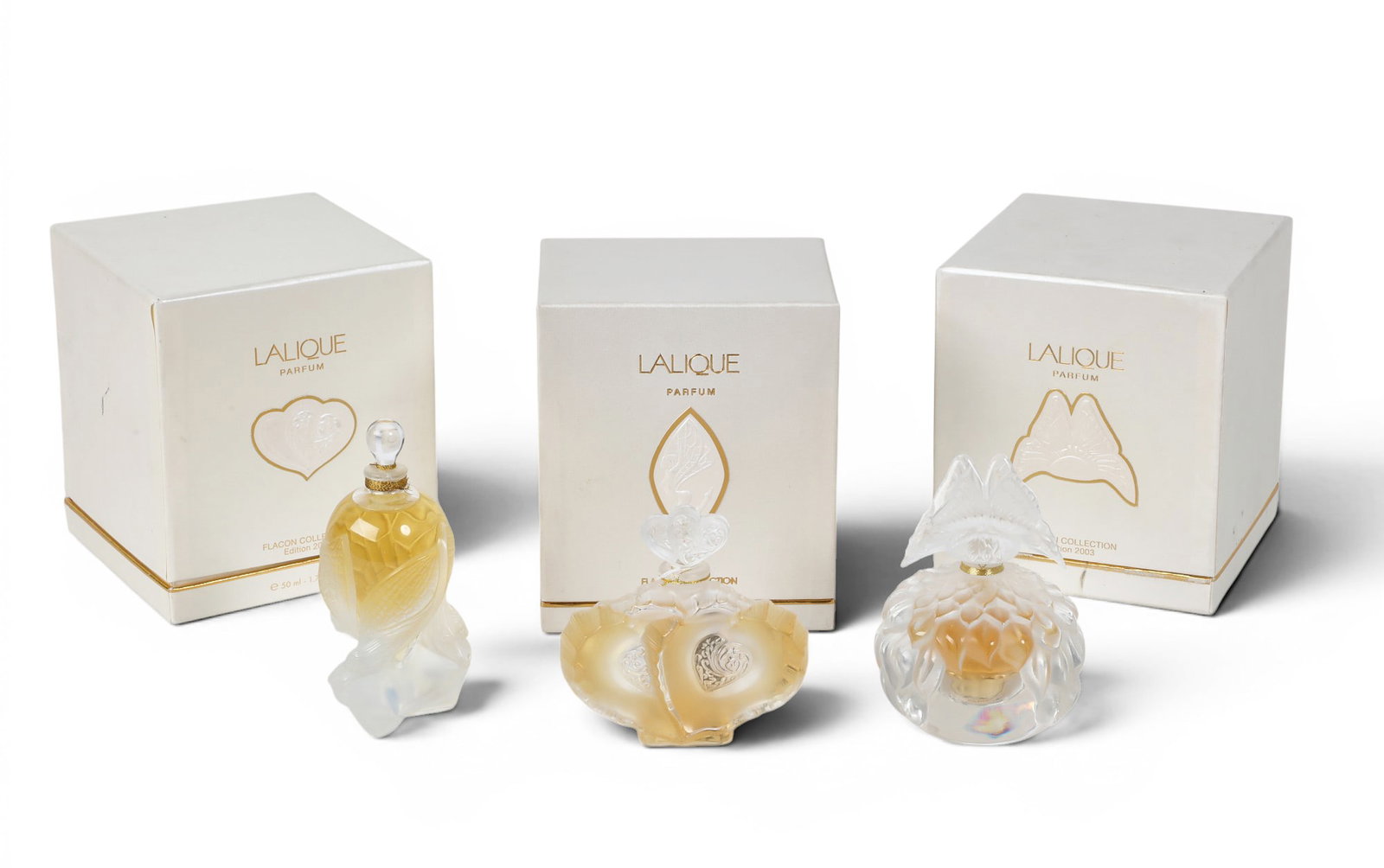 Three vintage limited edition Lalique parfum flacons, early 21st century: Three vintage limited edition Lalique parfum flacons early 21st century Comprising Elfes (2002), Butterfly (2003) and Deux Coeurs (2004), each with box and certificate. tallest bottle height 5 3/4in (