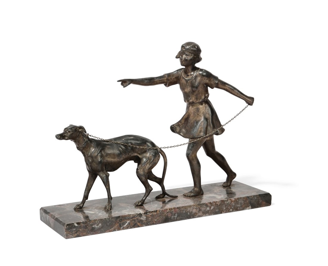 An Art Deco white metal figural group of a girl and her hound, second quarter 20th century: An Art Deco white metal figural group of a girl and her hound second quarter 20th century On a marble plinth. overall height 12in (30.5cm); width 15 3/4in (40cm); depth 4 1/2in (11.5cm)