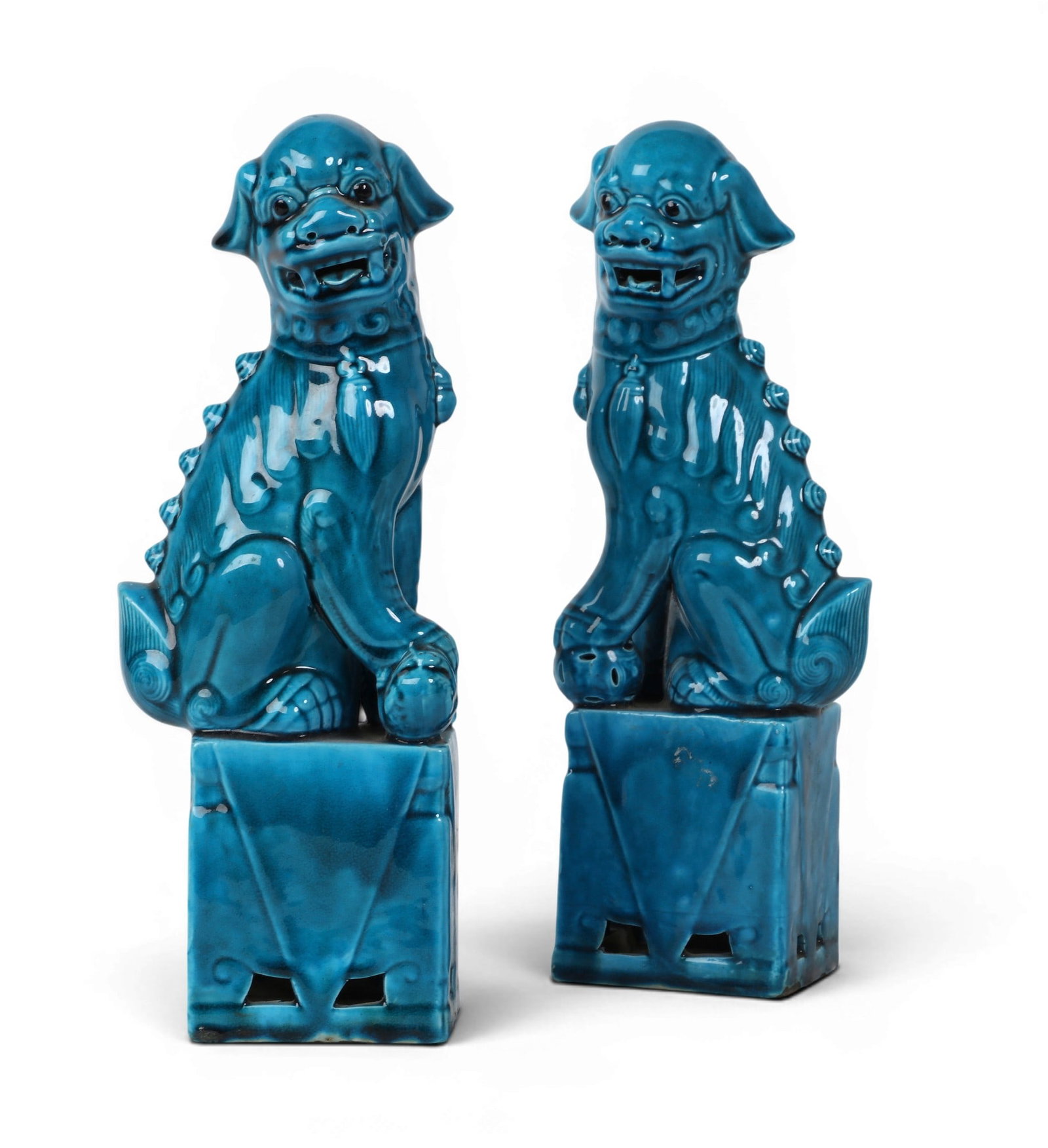 A pair of blue glazed foo dogs: A pair of blue glazed foo dogs height 12 1/2 x width 5 x depth 3 in. (31.8 x 12.7 x 7.6 cm.)