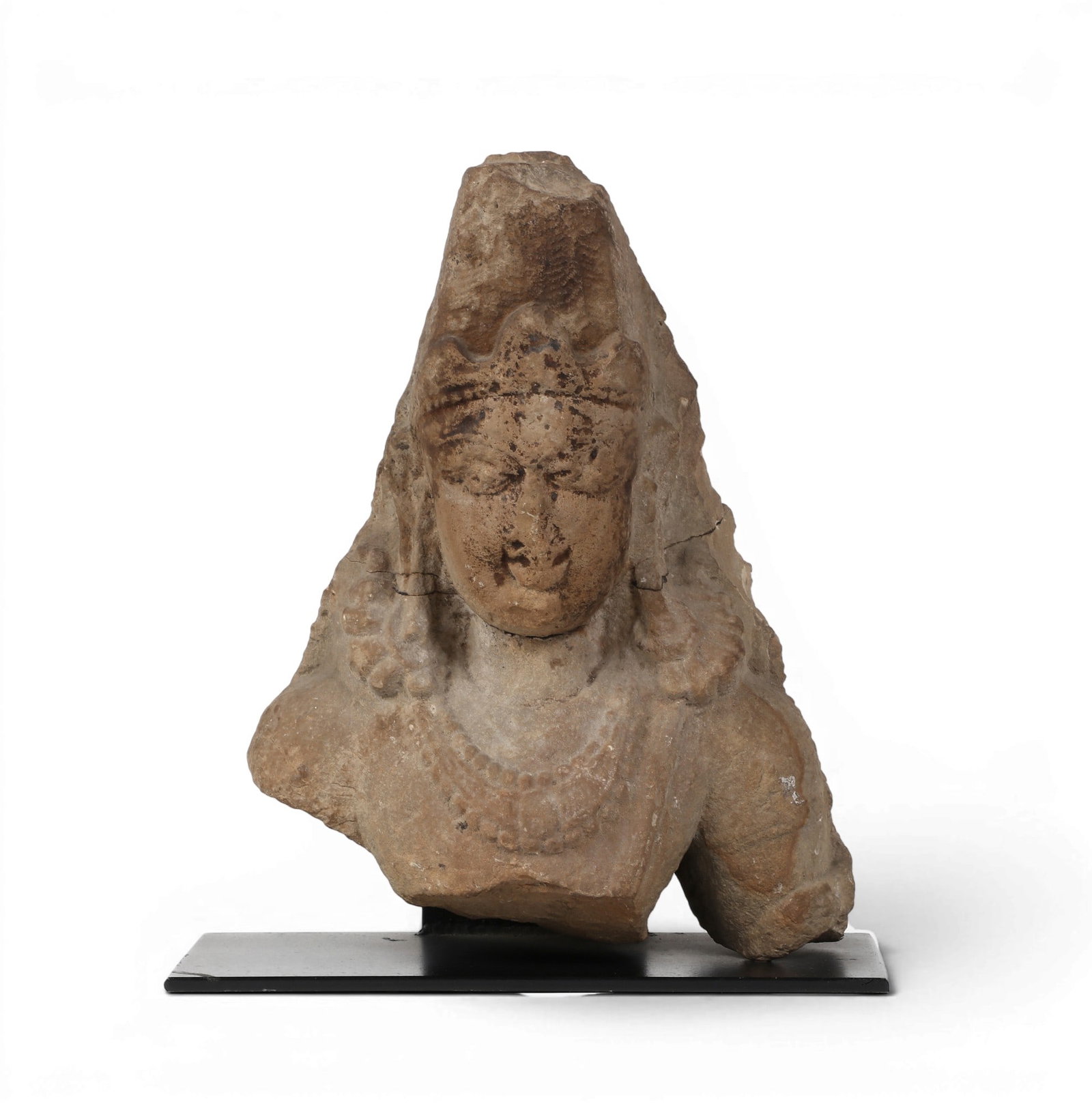 An Indian stone bust of a hindu: An Indian stone bust of a hindu Statue: height 13 x width 10 x depth 5 in. (33 x 25.4 x 12.7 cm.)