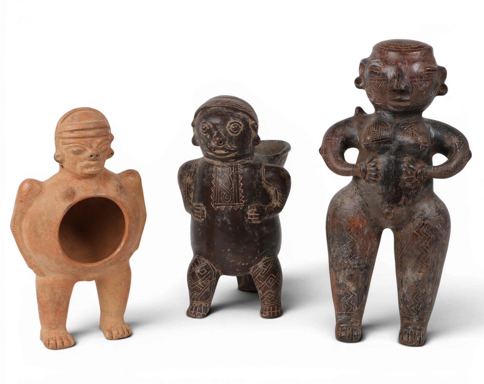 A group of three South American effigy guardian figures (1 of 4)