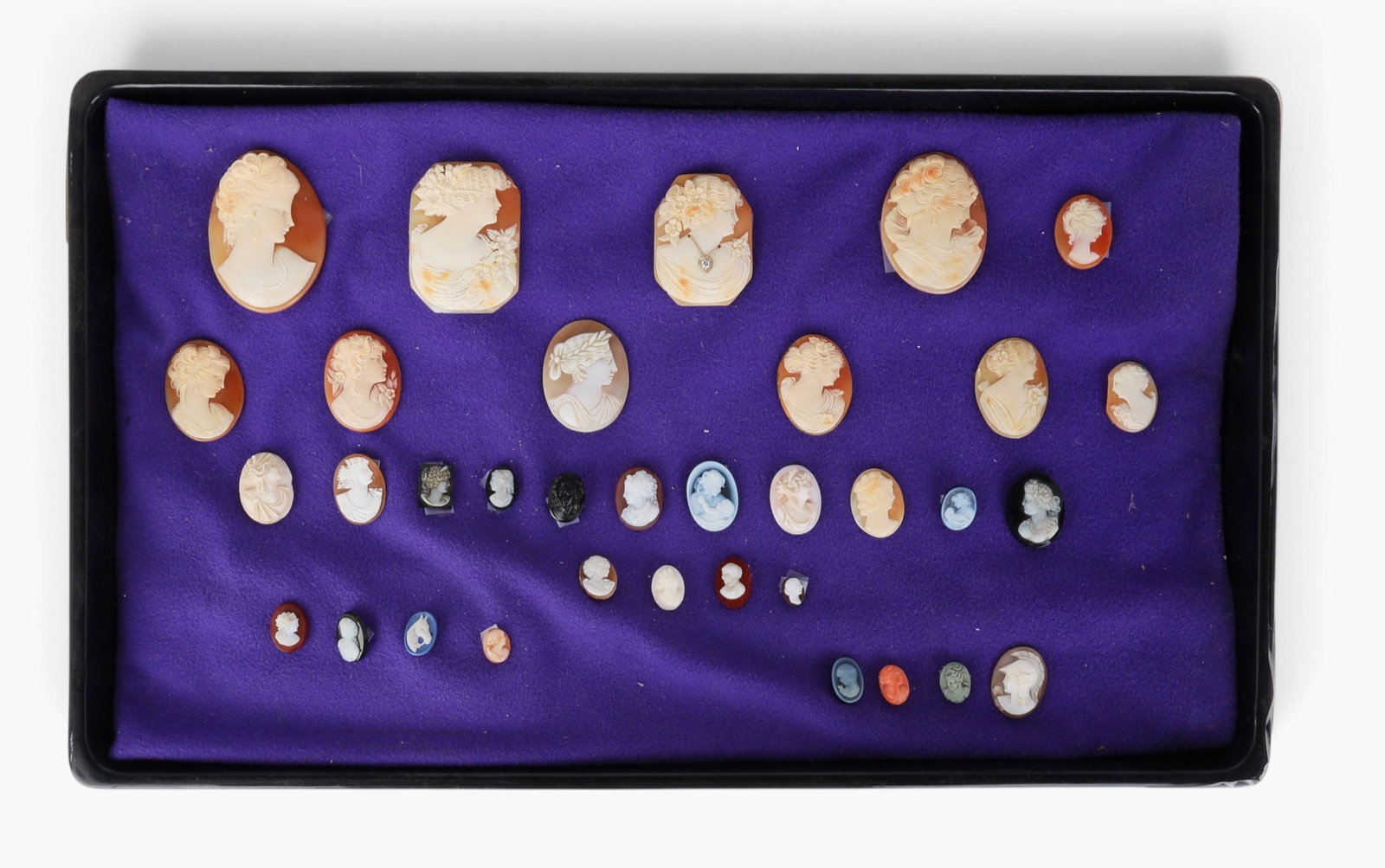 A collection of thirty-four shell and hardstone cameos, 19th/20th century: A collection of thirty-four shell and hardstone cameos 19th/20th century approximate heighs ranging from 1/3 to 2 1/4in (.85 to 5.7cm)
