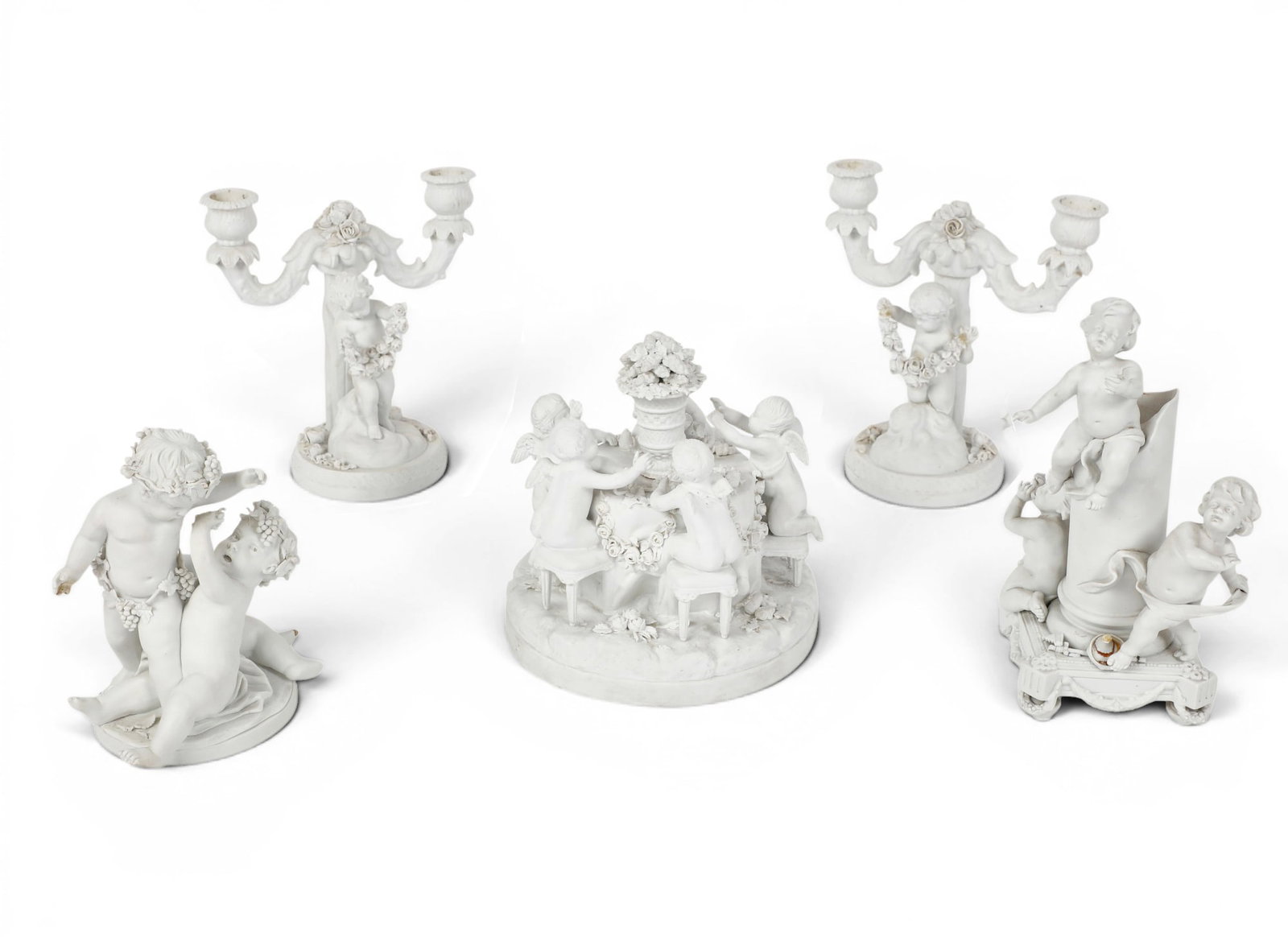 Five bisque porcelain figural groups and table decorations, Sevres and other makers, 20th century: Five bisque porcelain figural groups and table decorations Sevres and other makers 20th century Comprising a Sevres Bacchanalian putti group on later giltwood stand, with incised interlaced Ls and imp