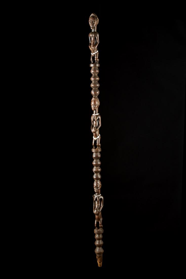 Ceremonial Songye Wooden Cane Tribal Art: An elegant, long Songye cane. The cane is decorated with three figures. A man on top and two women below. All figures are decorated with small white beads. Provenance: Simon du Chastel de la Howarderi