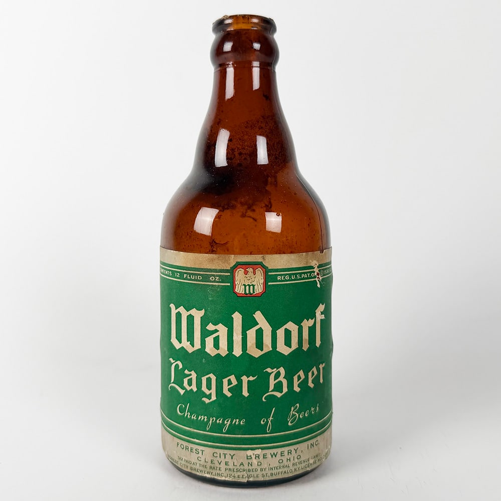 Waldorf Lager Beer Steinie Bottle Forest City Brewery Cleveland OH: Circa 1930s Waldorf Lager Beer steinie bottle from Forest City Brewery, Cleveland, Ohio. Features a green label with gold lettering. 12 fluid oz. 