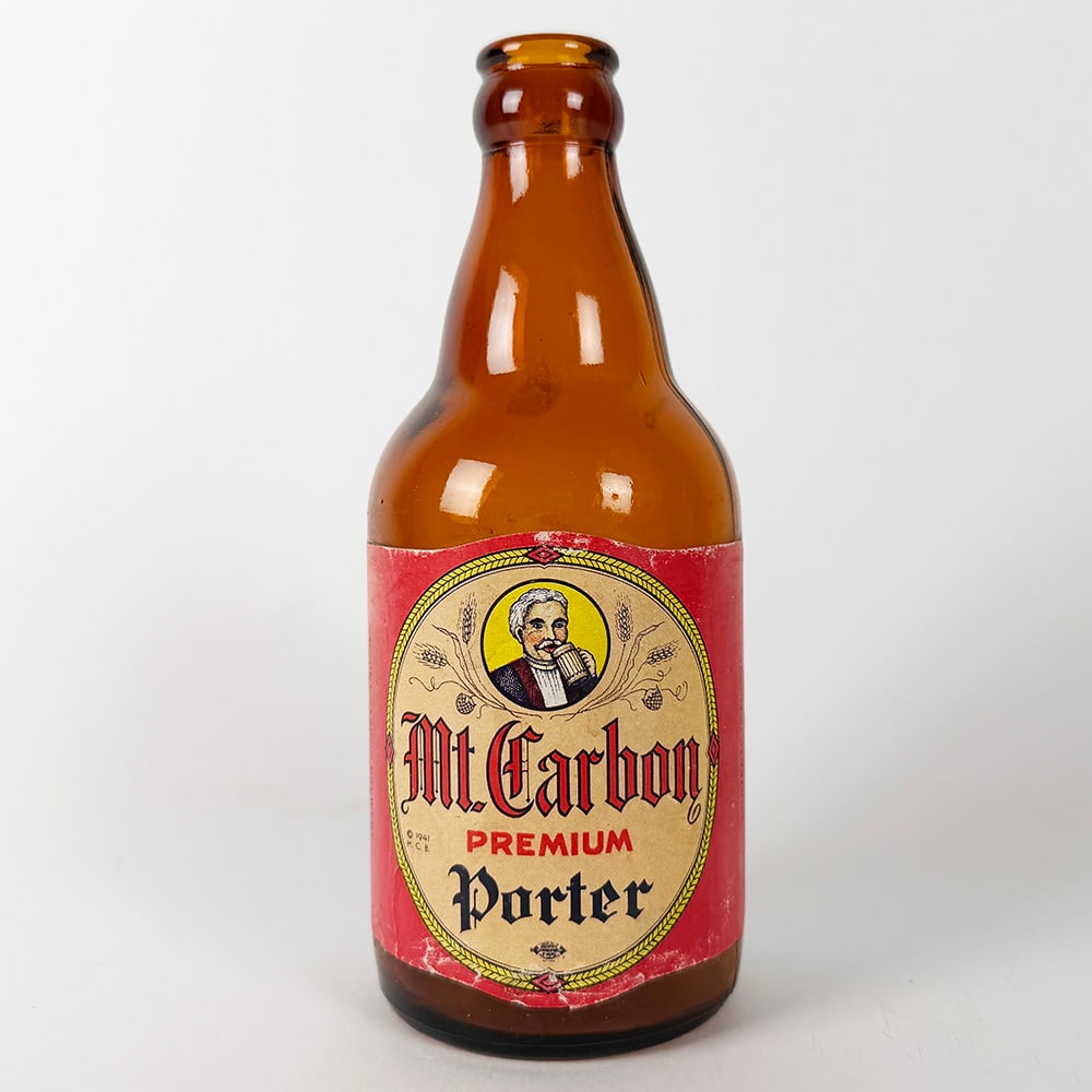 Mt. Carbon Premium Porter Beer Steinie Bottle Pottsville PA: Circa 1940s Mt. Carbon Premium Porter beer bottle. Features a paper label with the trademark drining man. Contents 12 fl. ozs.