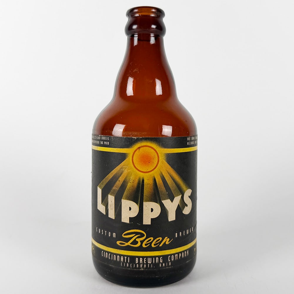 Lippys Custom Beer Steinie Bottle - Cincinnati Brewing OH: Circa 1940s Lippys Custom Beer steinie bottle from the Cincinnati Brewing Company, Cincinnati, Ohio. Features a black label with gold accents and the Lippys sun inspired logo. 