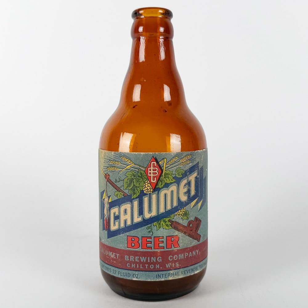 Calumet Beer Steinie Bottle Chilton WI: Circa 1940s Calumet Beer steinie bottle from Calumet Brewing Company, Chilton, Wisconsin. Marked 'Contents 12 Fluid Oz.' and 'Internal Revenue Tax Paid'.