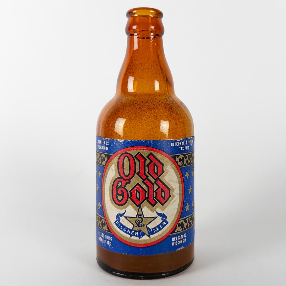 Old Gold Pilsner Beer Bottle Reedsburg Brewery WI: Circa 1940s Old Gold Pilsner steinie beer bottle from Reedsburg Brewery, Reedsburg, Wisconsin. Features a blue and red label with gold lettering and star design. 12 fl. oz. capacity.