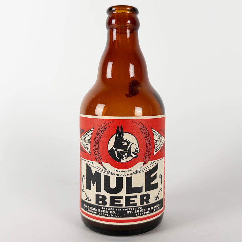 Mule Beer Steinie Bottle - McGovern Brewing Trenton IL: Circa 1940s Mule Beer steinie bottle from McGovern Brewing Co., St. Louis, Missouri & Trenton Brewing Co., Trenton, Illinois. Features a red and black label with a mule graphic. 