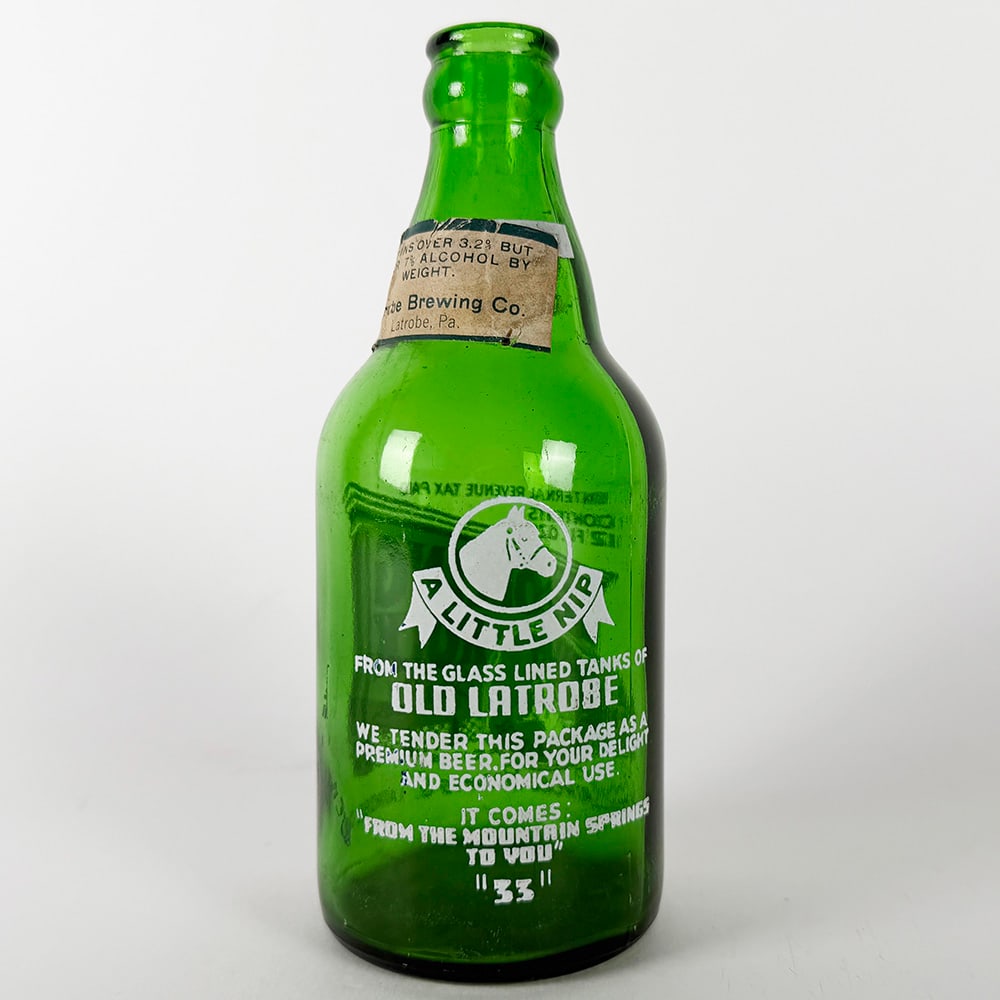 Rolling Rock Beer ACL Steinie Bottle - Latrobe Brewing PA: Circa 1940s green glass Rolling Rock beer ACL steinie bottle from Latrobe Brewing Co., Latrobe, Pennsylvania. Features "A Little Nip from the Glass Lined Tanks of Old Latrobe" and "Roll