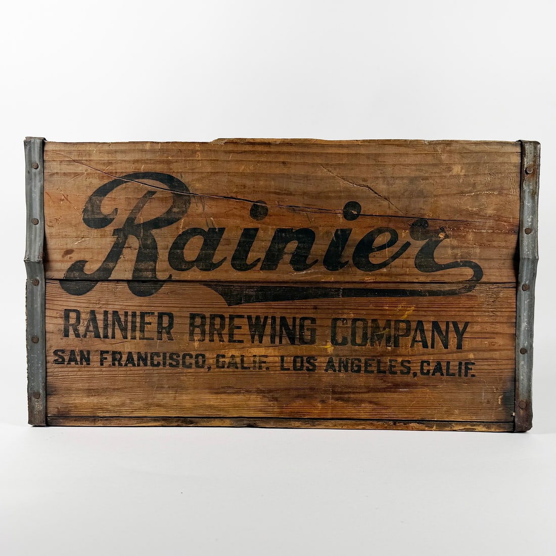 Rainier Brewing Company Wooden Crate LA & SF CA: Circa 1930s wooden crate from Rainier Brewing Company, San Francisco and Los Angeles, California. Features black lettering and metal corner reinforcements. Rustic appearance. 18 x 12 x 10 inches.