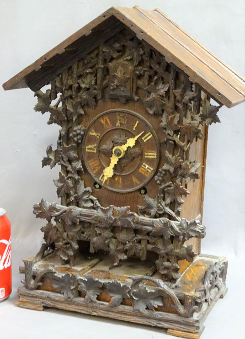 Black Forest Style Mantel Clock: Black forest mantel clock with carved leaf and grape design. Missing some numerals. 15" tall, 10" wide, 7" deep.