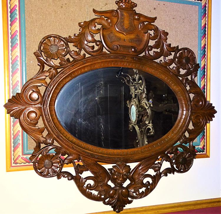 Monumental 57" Black Forest 19th C. Mirror: Monumental 57" black forest mirror in oak with winged face carvings - shield and crown crest. 54" tall, 57" wide.