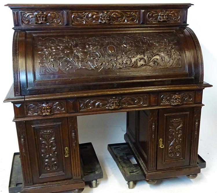 Heavily Carved 55" Oak Cylinder Roll with North Wind: Awesome heavily carved oak cylinder roll with fully carved cylinder and (6) drawers with carved faces and a fitted interior with a tooled leather writing surface. 52" tall, 55 wide, 32" deep.