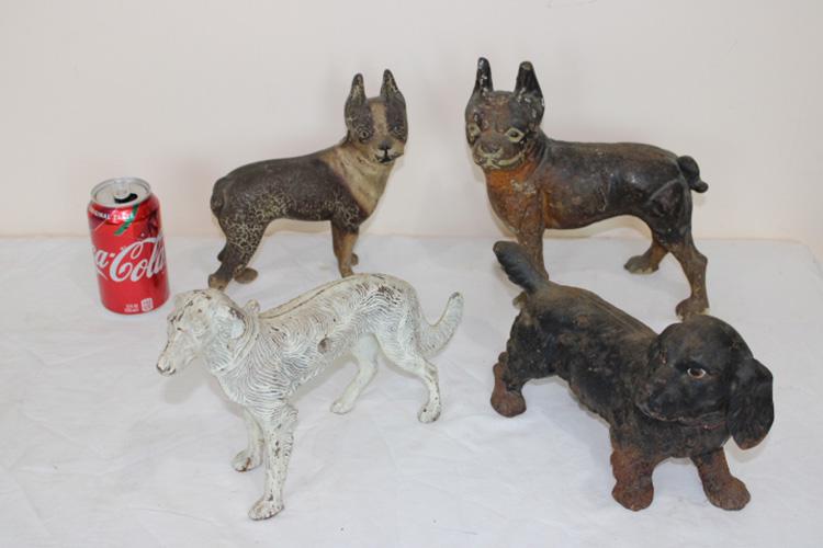 4 Antique Dog Door Stops: 4 antique dog door stops. A couple in original paint, some with a little rust.