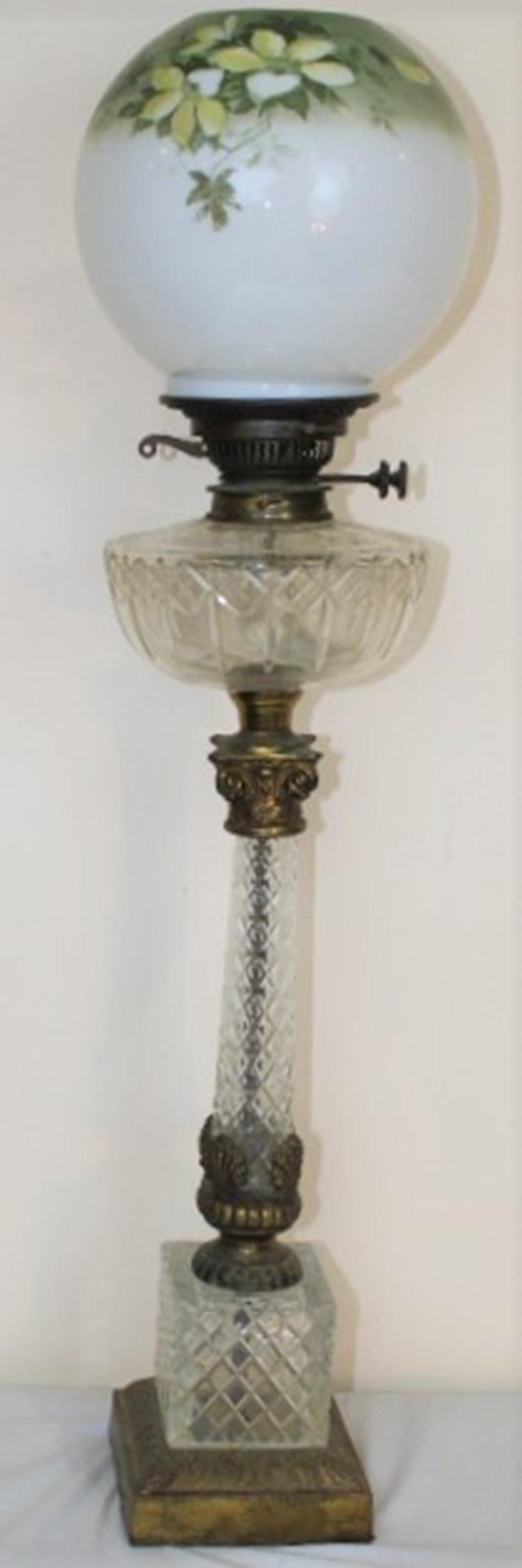 Cut Glass Piano Lamp: Cut glass piano lamp with a Corinthian column and painted ball shade. 8" wide, 31" tall.