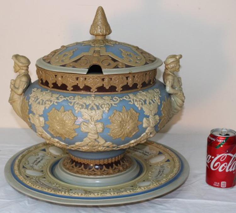 Fine Signed Mettlach Tureen: Fine signed mettlach (Villeroy & Bach) tureen on a cameo design with figural handles with matching under plate. Small line in the making. 16" wide,15" tall.