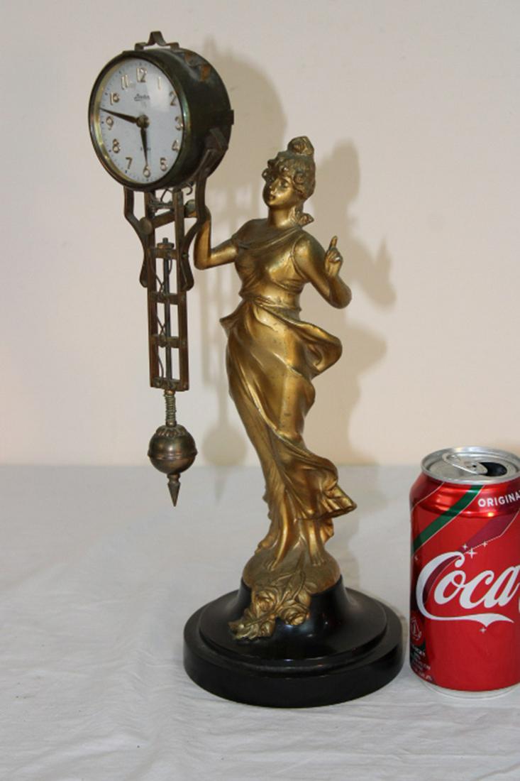 Swinging Arm Clock: Swinging arm clock with nouveau lady with gold wash, marked Linden 8-day. Swings then stops, spring is good. 5" wide, 14" tall, 5" deep.