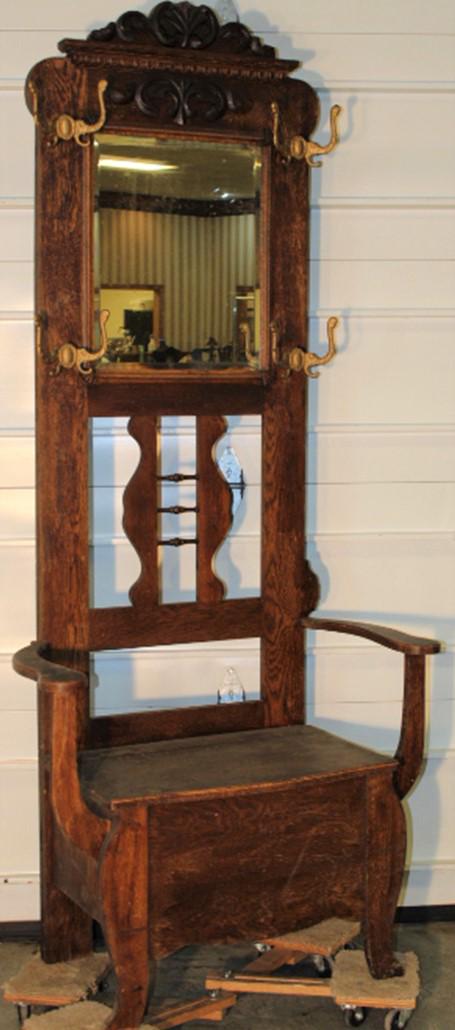 Oak Hall Tree with Original Hooks: Oak hall tree with original hooks, beveled mirror, carved top, and lift seat in an old finish. 34" wide, 81" tall, 18" deep.