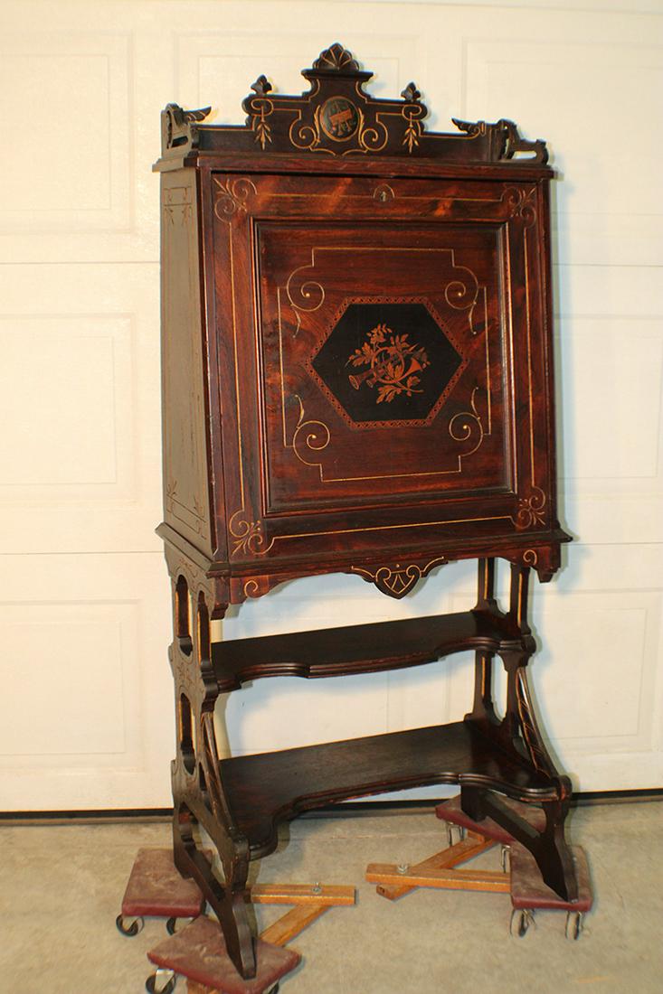 Super Rosewood Drop Front Desk with Inlaid Instruments: Super rosewood drop front desk with inlaid instruments with gold incising and super crest. Has a 5" piece added to the bottom (see photo). 27" wide, 62" tall, 13" deep.
